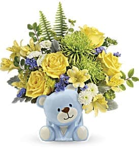 Yellow and white flower arrangement with blue accents in a light blue ceramic teddy bear vase