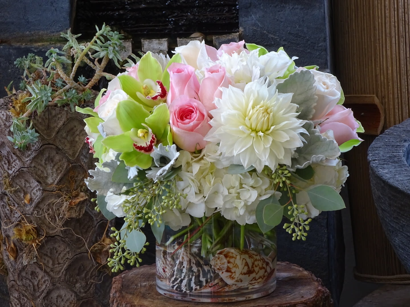 Pink roses and white flowers arranged in a glass vase
