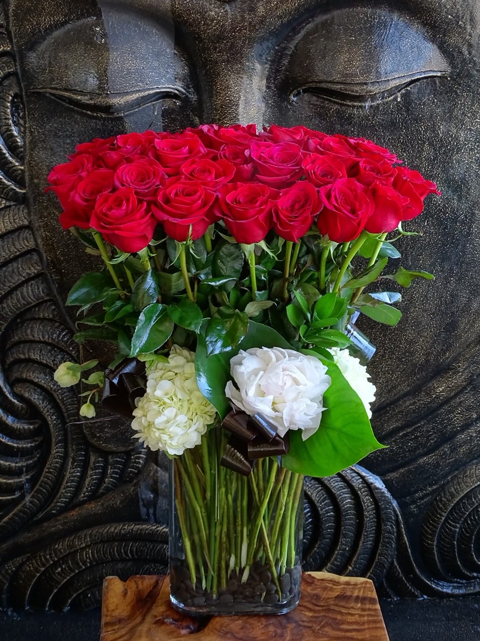 Red roses and white blooms arranged in a clear glass vase