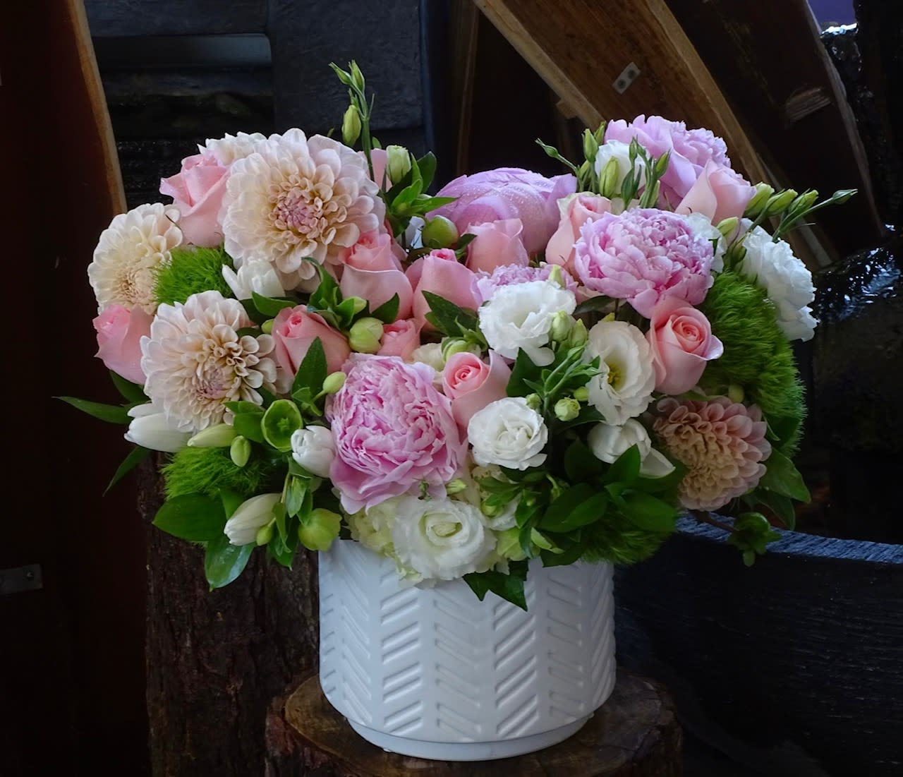 Pink and white mixed flower arrangement in a white vase