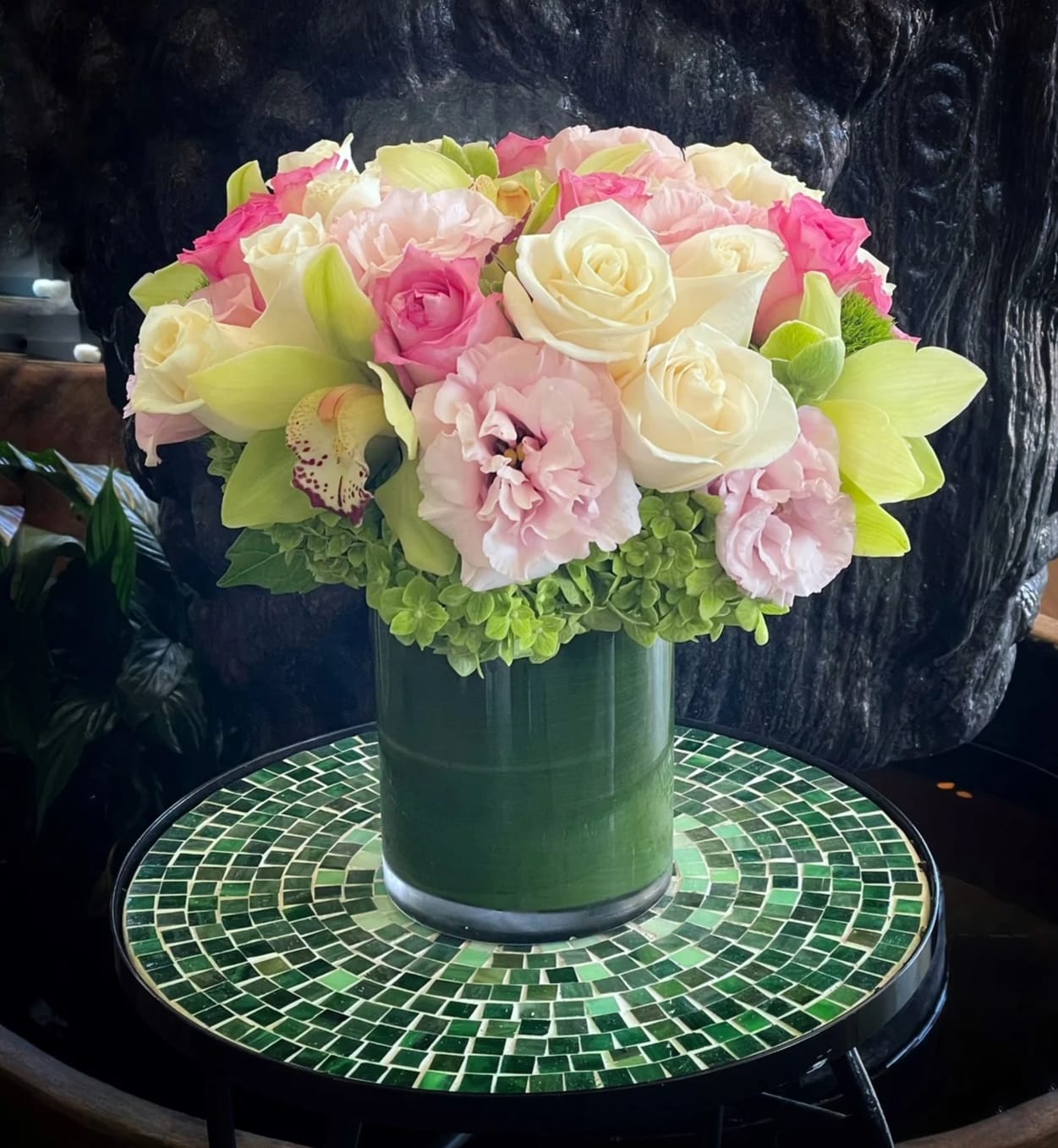 Pink and white rose bouquet in a green vase