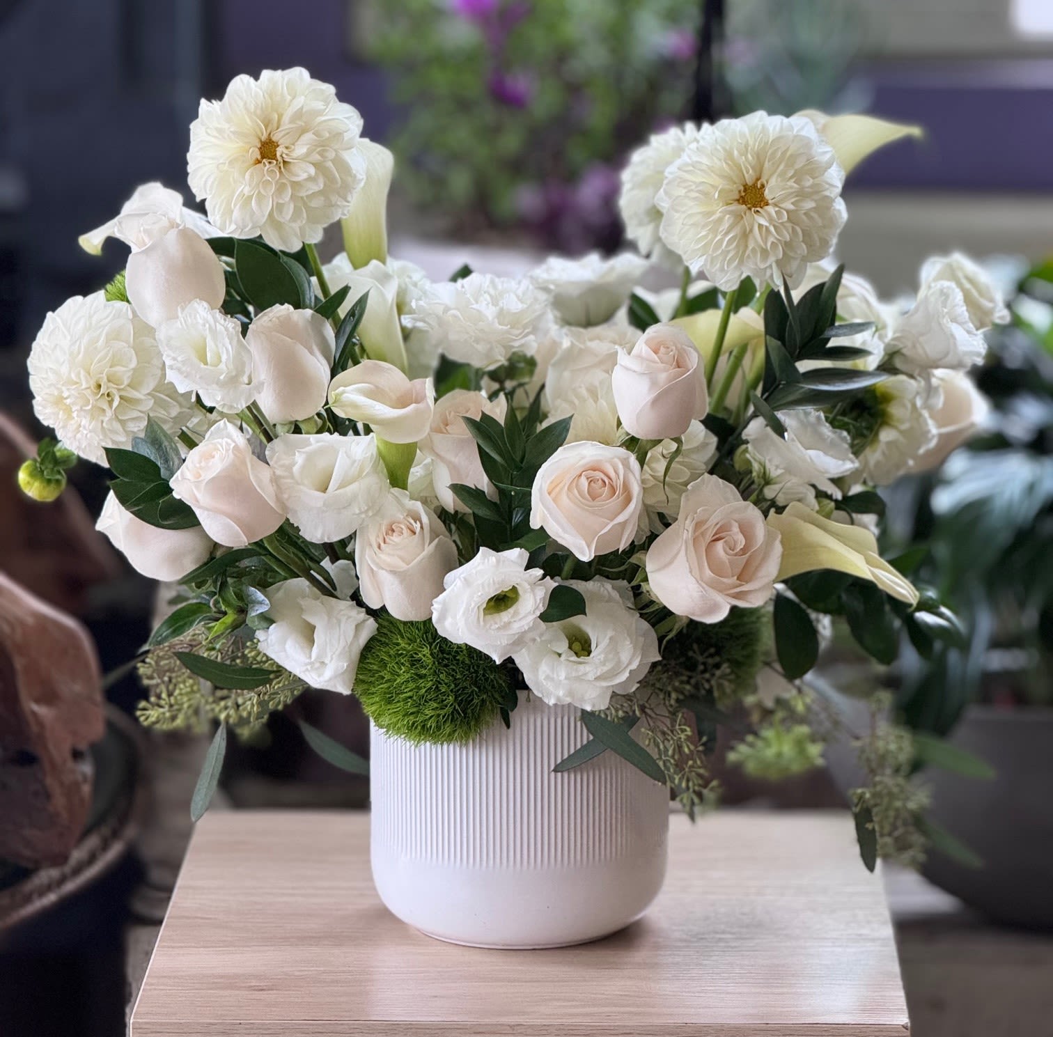 White floral arrangement in a ribbed white vase