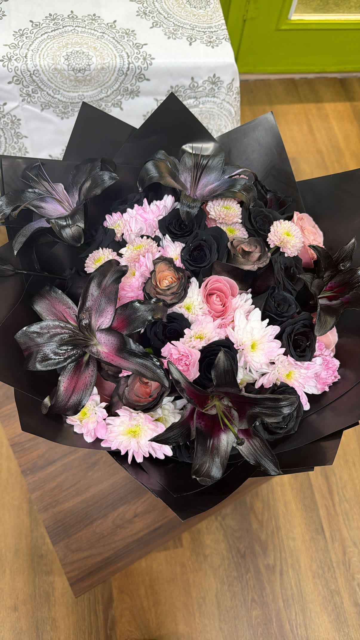 Bouquet of pink and black flowers wrapped in black paper