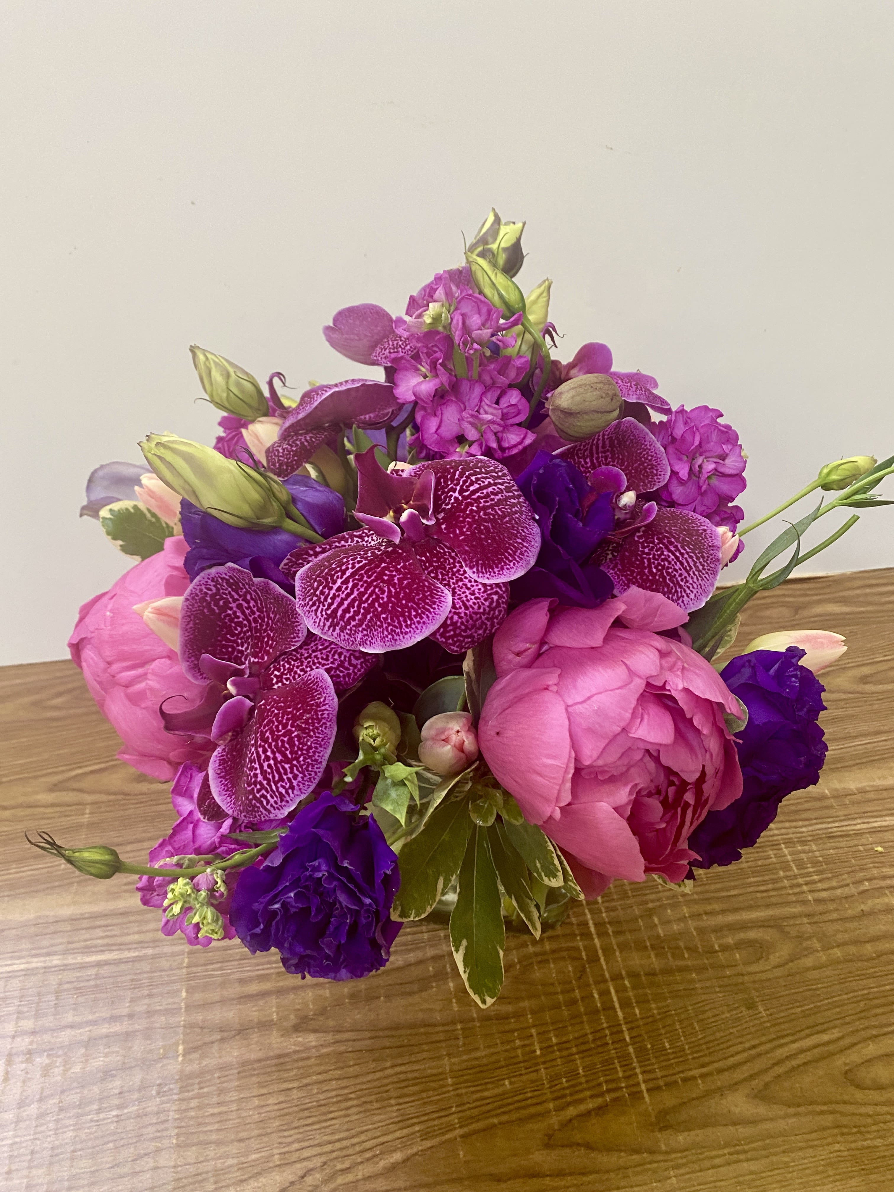 Pink and purple bouquet with orchids and peonies on a table