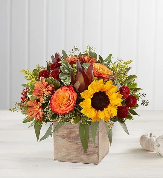 Harvest Glow Bouquet - The color and charm of an autumn country harvest inspired our farmhouse-style bouquet. A loose, natural gathering of blooms in vibrant shades of red, orange and yellow creates the perfect complement to our rustic, grey-washed wooden cube. With its soft tones and natural textures, it’s an ideal container for flowers and plants, adding warm and coziness to any fall décor.