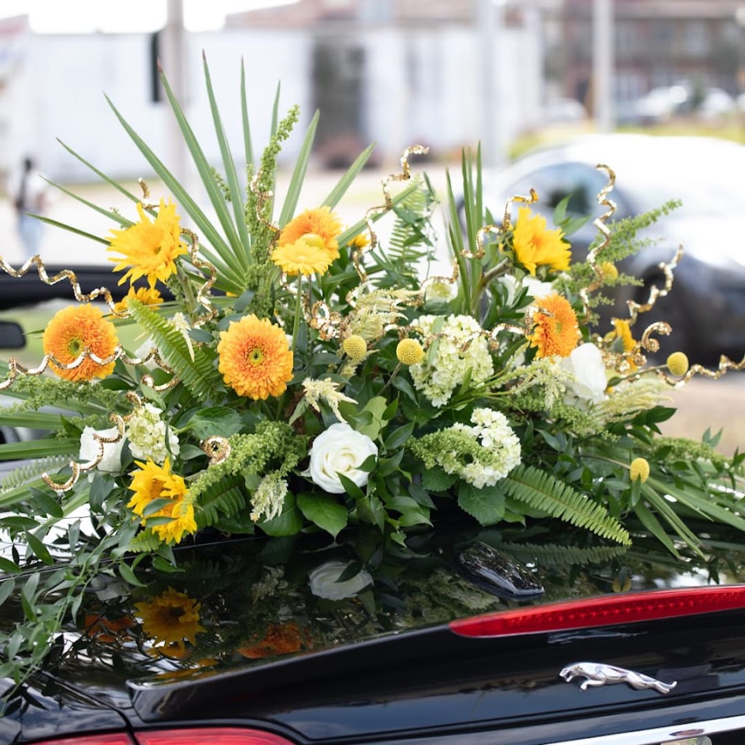 Yellow and white floral arrangement on a car trunk