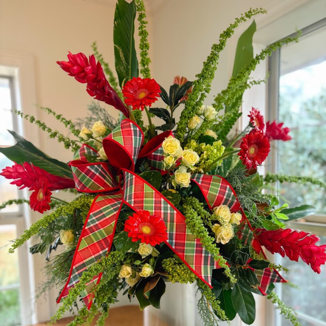 Red gerbera daisies and yellow spray roses with plaid ribbon in a vase
