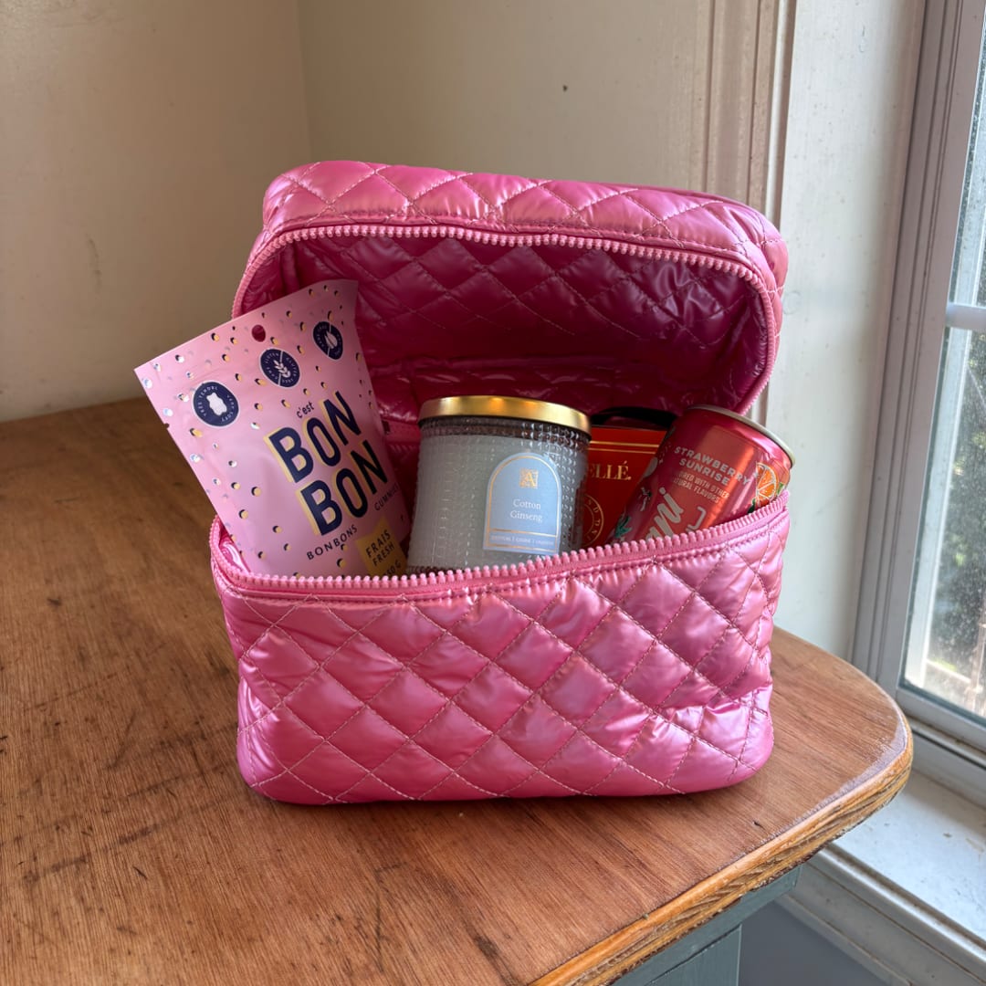 Pink quilted gift bag with candy and candles inside