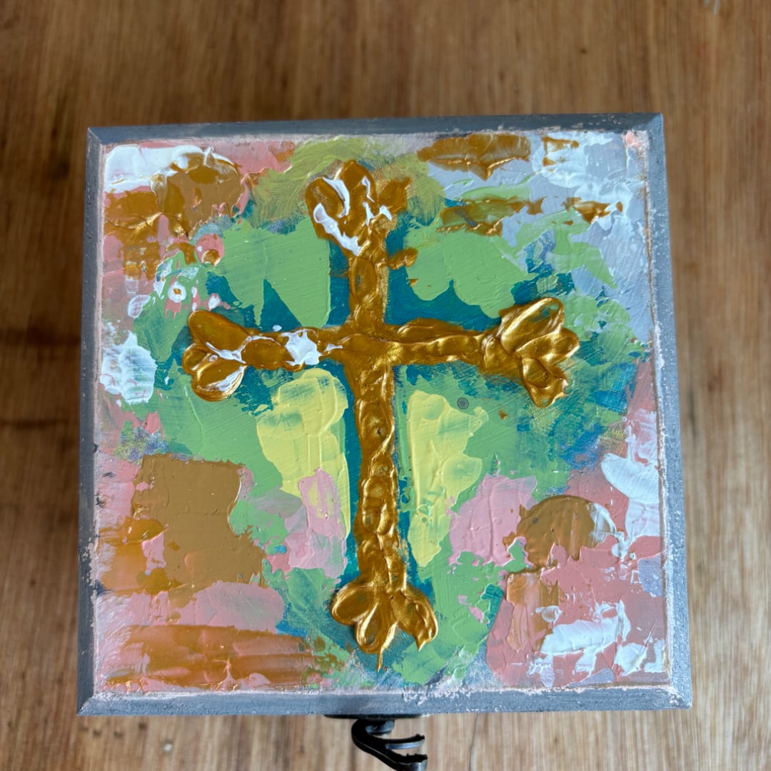 Abstract painted square box with a gold cross on a colorful background