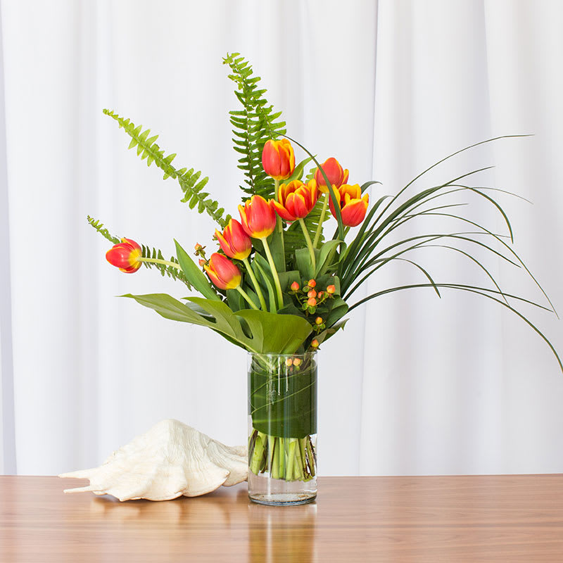 Vivid Spring Tulips (Featured item)  - Tulip fans, here it is! This colorful contemporary design featuring the popular Washington State Tulip is sure to impress. Perfectly sized at approximately 21 inches high by 16 inches wide, this vibrant arrangement adds a touch of modern elegance to any space.  Key Features:  Washington State Tulips: Showcases the popular and beloved tulips from Washington State, known for their vibrant colors and exceptional quality.  Contemporary Design: Features a stylish and modern arrangement that stands out with its artistic flair and colorful appeal.  Perfect Size: Measures approximately 21 inches in height and 16 inches in width, making it ideal for a variety of settings, from home decor to office spaces.  Vibrant and Cheerful: Adds a splash of color and joy to any room, brightening up the environment with its lively and cheerful presence.  Impressive Gift: A wonderful gift for tulip enthusiasts and anyone who appreciates contemporary floral design, suitable for any occasion.  Delight in the beauty of our Colorful Contemporary Tulip Arrangement and enjoy the elegance and charm it brings to your decor.