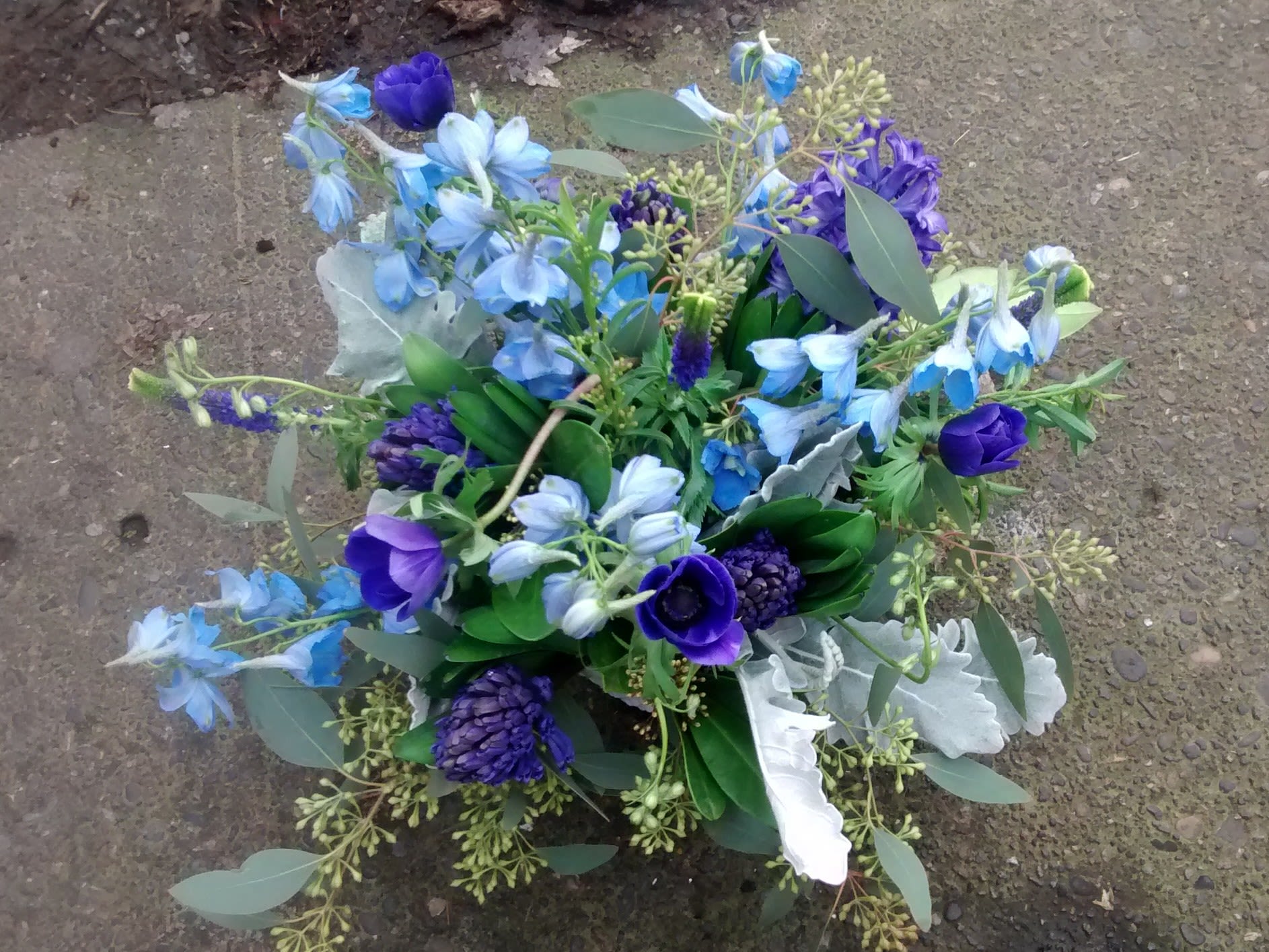 Compact bouquet of deep purple and blue flowers arranged in a rounded cluster