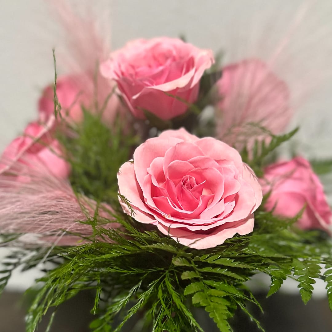 Pink roses arranged with airy greenery