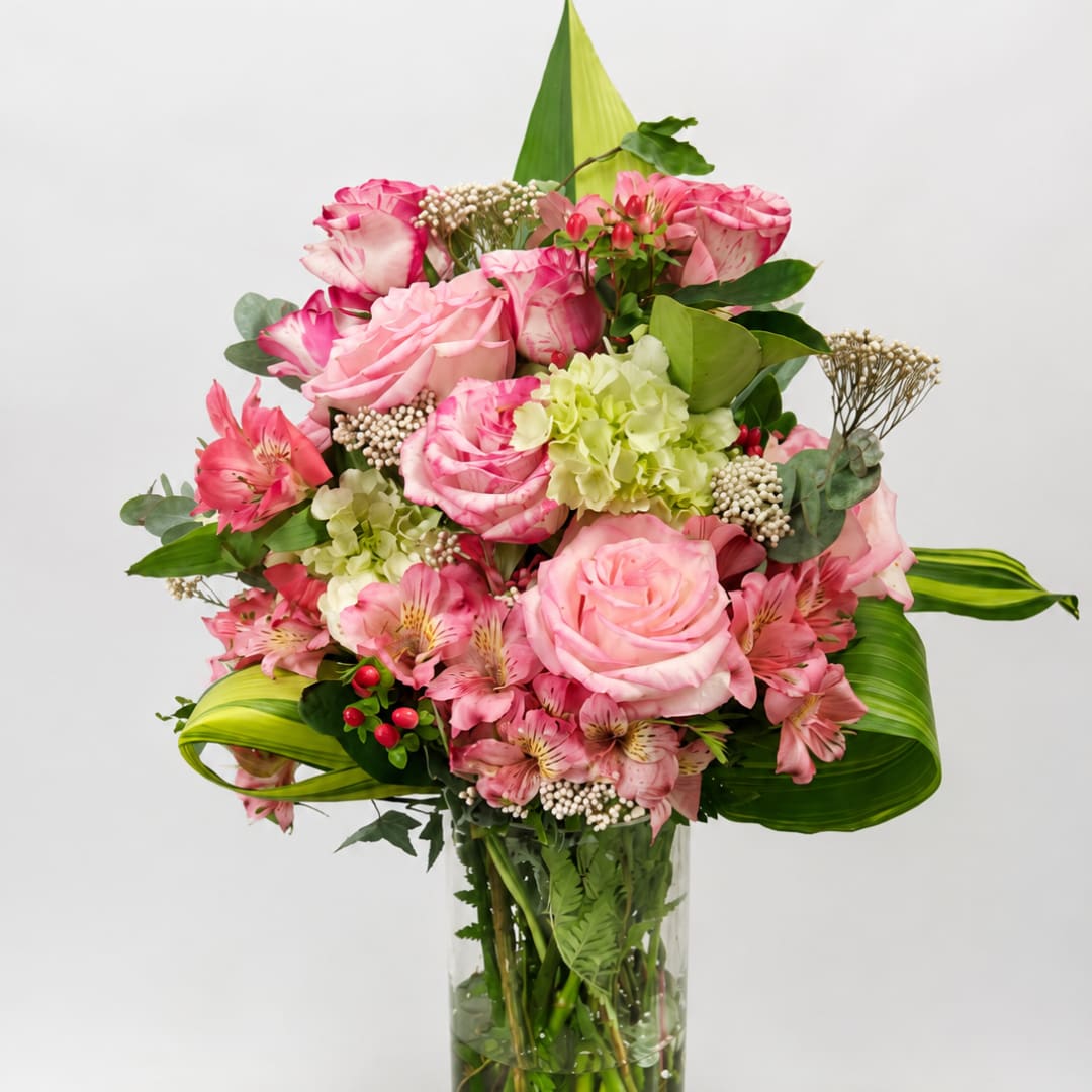 Pink roses and alstroemeria arranged in a clear glass vase