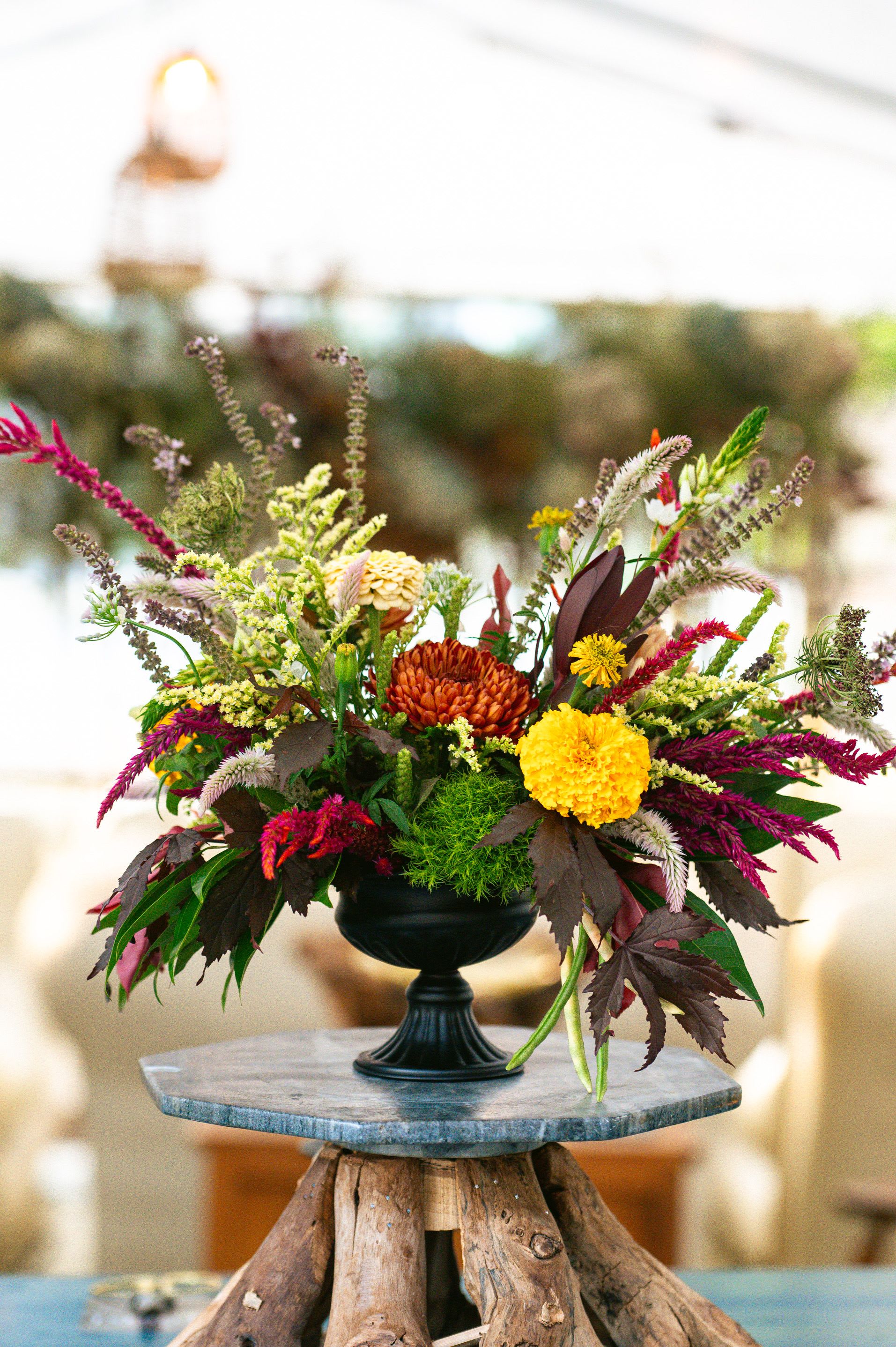 Colorful floral arrangement in a black pedestal vase