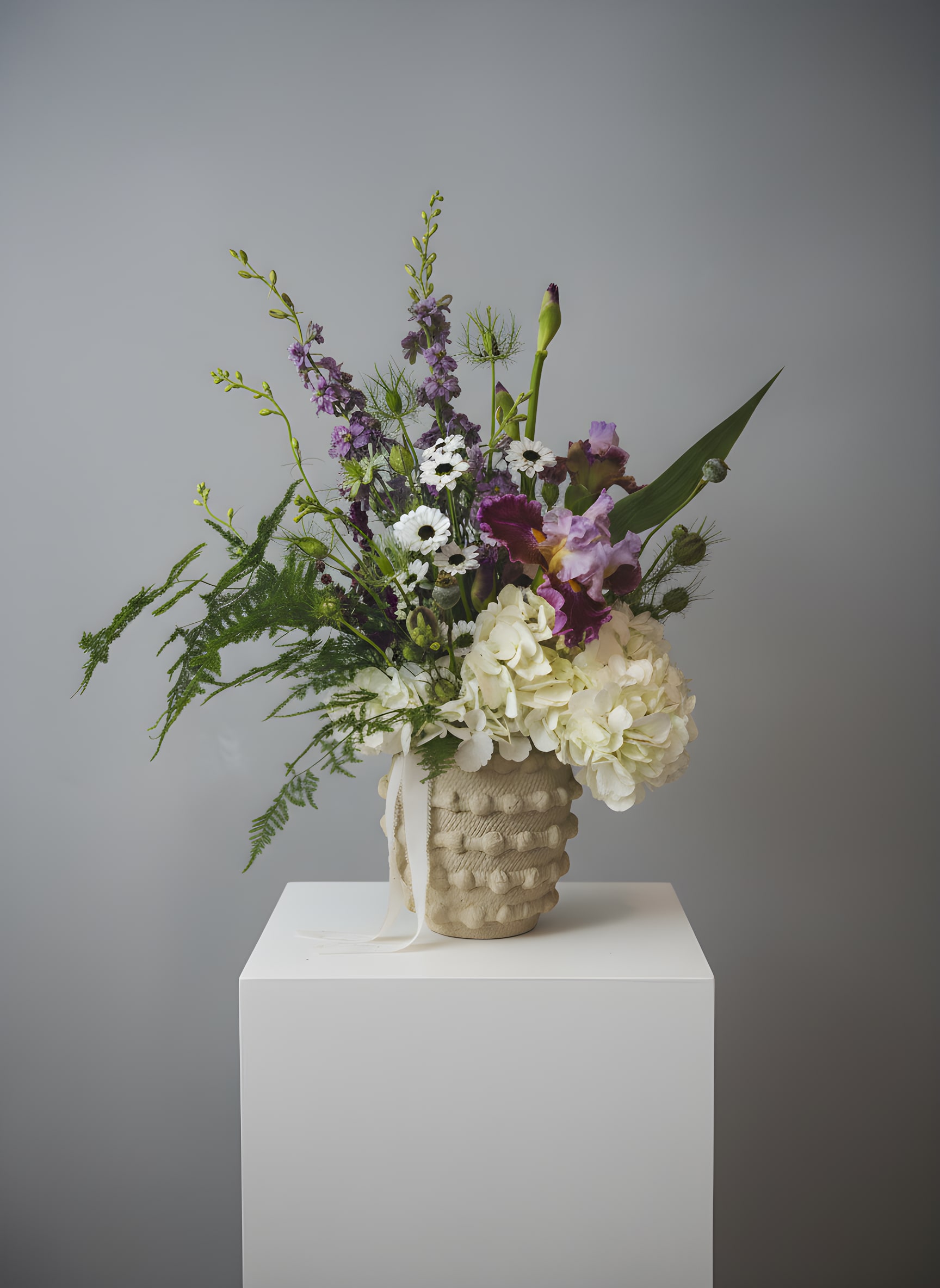 From the Fairy Garden - **IF YOU ORDER THIS ARRANGEMENT, IT WILL NOT INCLUDE IRIS THIS WEEK, SO SORRY.  *Vase will be the same  Because flowers follow the rhythm of the seasons, their availability often changes often. Your arrangement may vary slightly from the photo, and some filler and accent varieties may differ. We design with the freshest blooms available, making substitutions when needed—while always preserving the overall mood and shape. Always fresh, artful, and beautifully composed.  The arrangement delivered will be inspired by this photo.  For specific flower or color requests, please contact us before ordering.