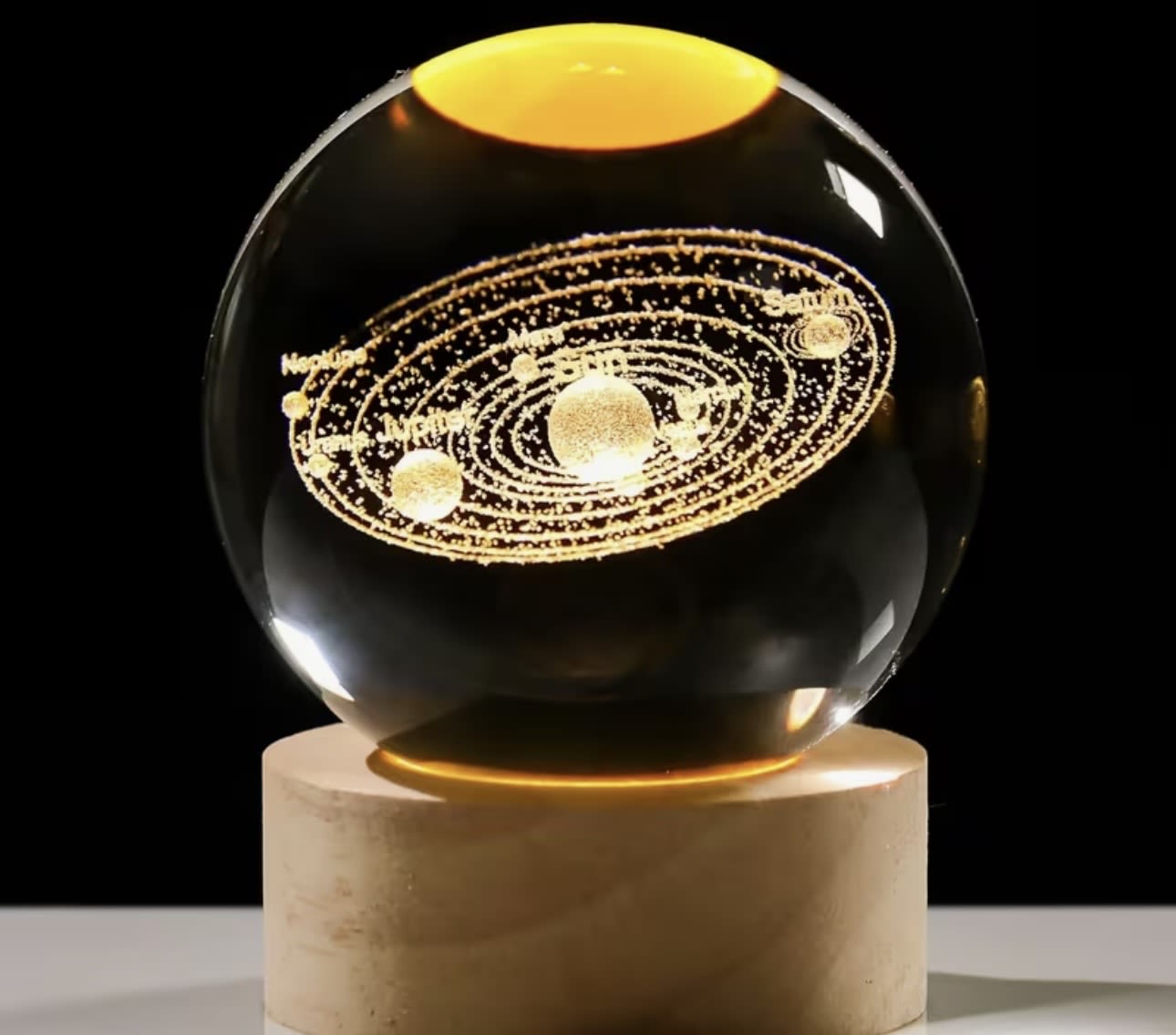 Glass orb with a glowing solar system design on a pedestal