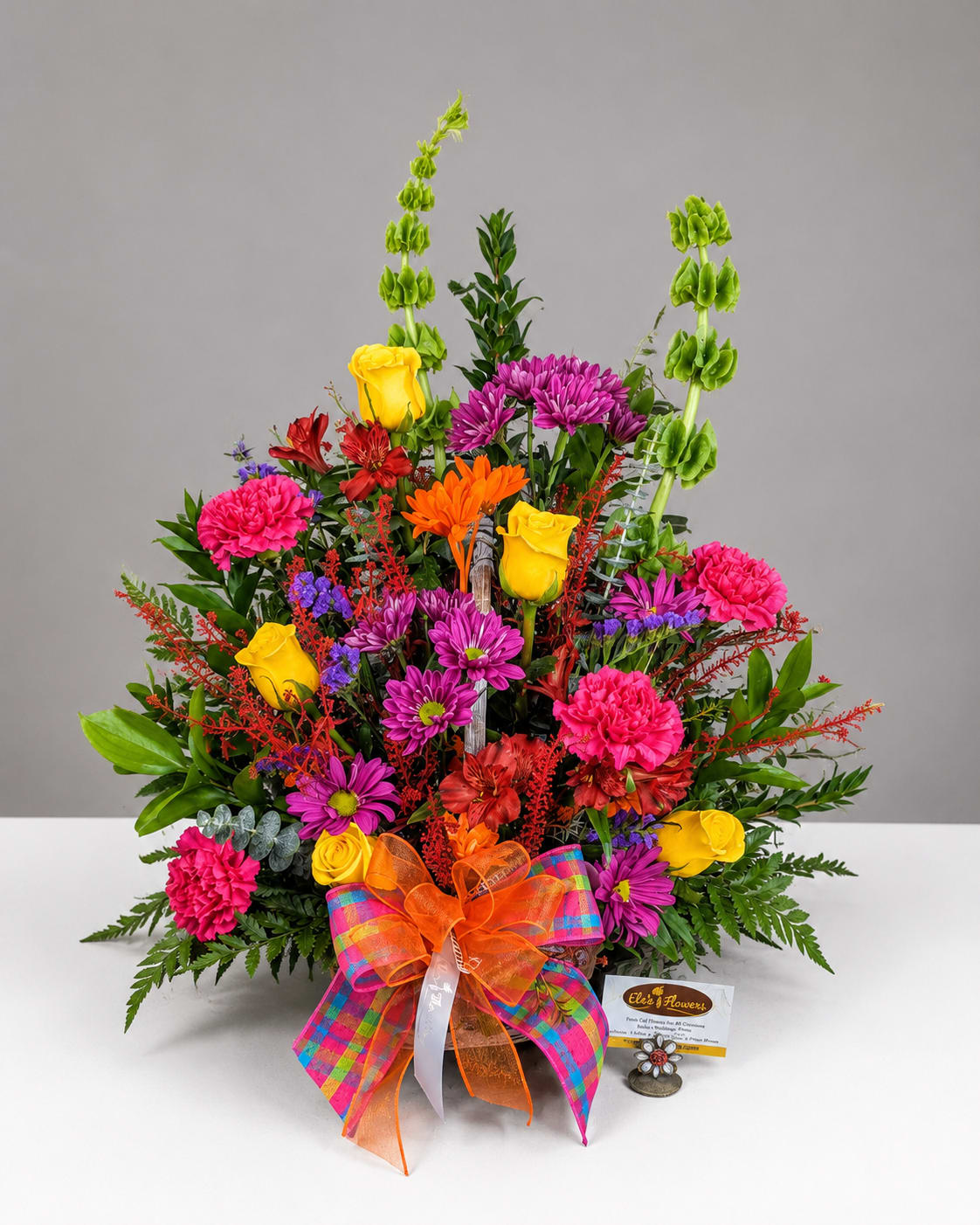 Colorful mixed bouquet with roses, chrysanthemums, carnations, and a plaid ribbon bow