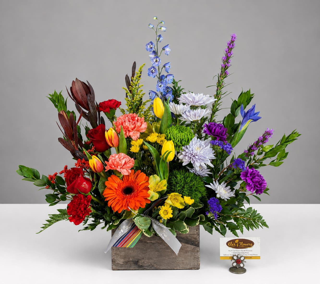 Colorful mixed flower arrangement in a rustic wooden box