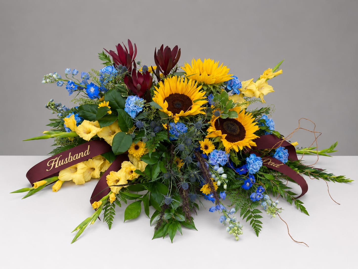 Colorful bouquet with sunflowers, blue flowers, and burgundy blooms