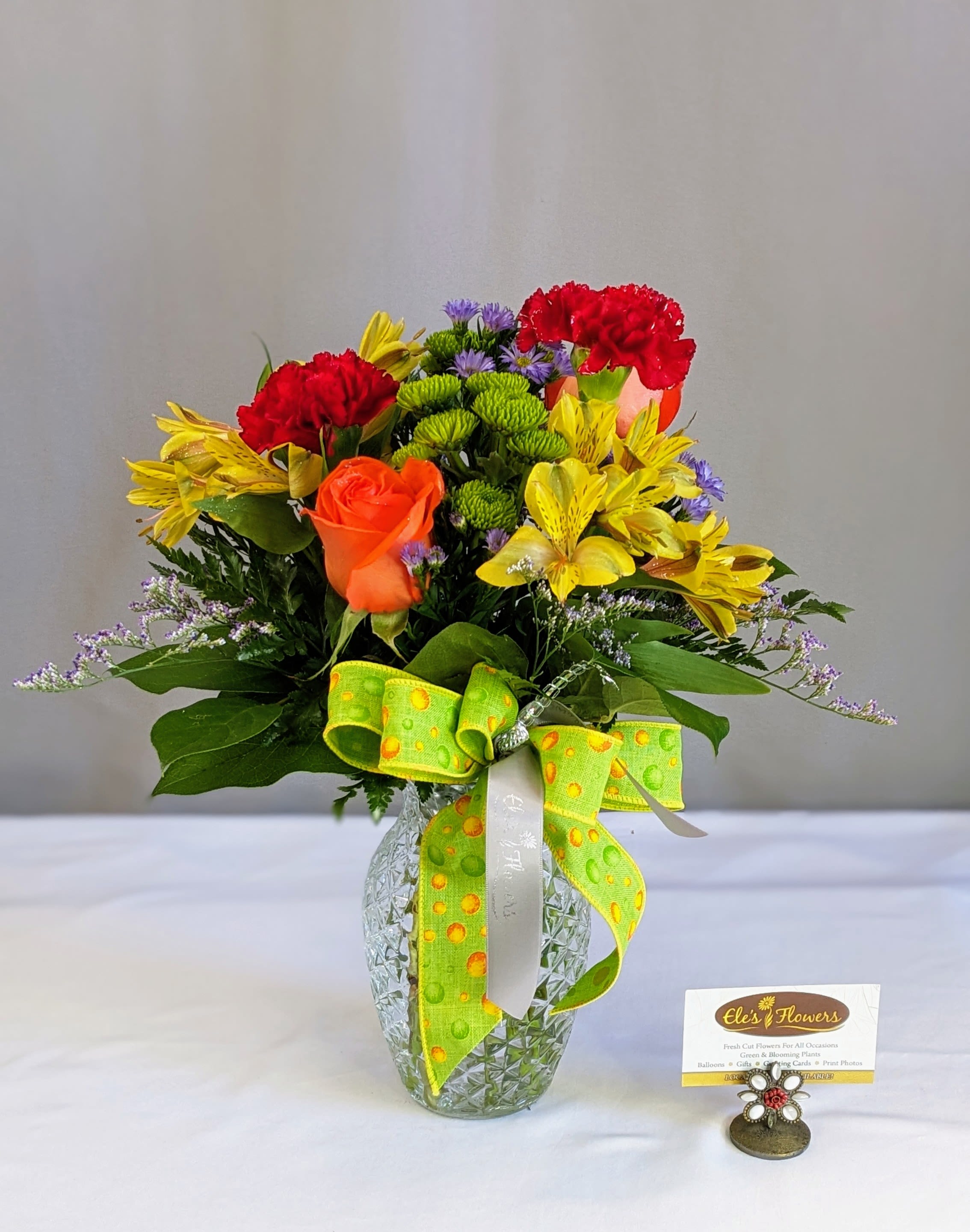 Mixed bouquet in a glass vase with red, yellow, and orange flowers