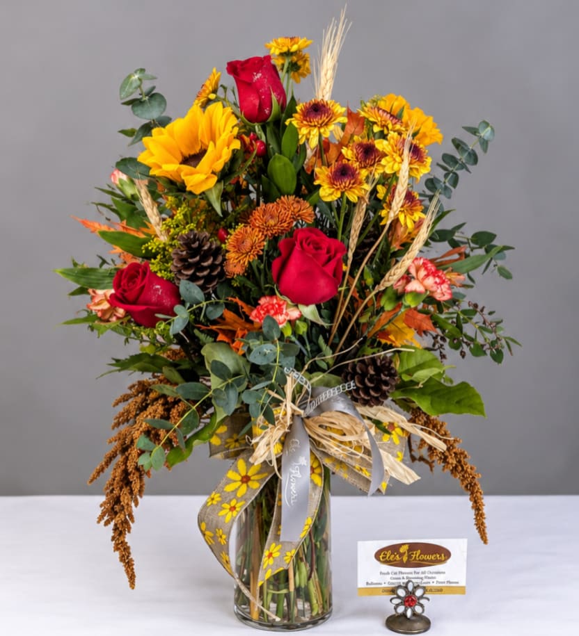 Mixed bouquet of red roses and sunflowers in a glass vase