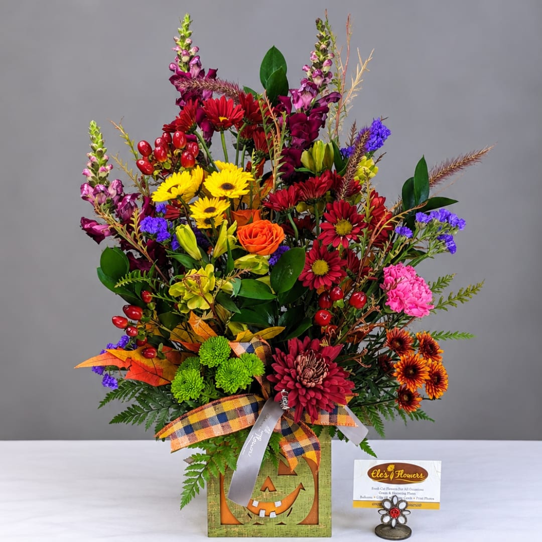 Mixed bouquet in a Halloween-themed box with bright fall flowers