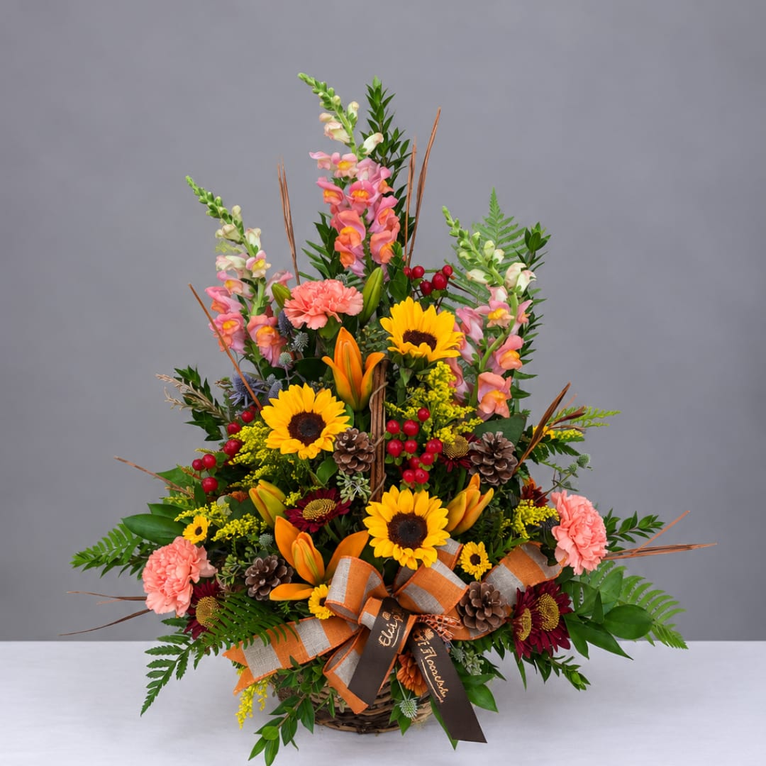 Basket arrangement with sunflowers, lilies, carnations, and snapdragons