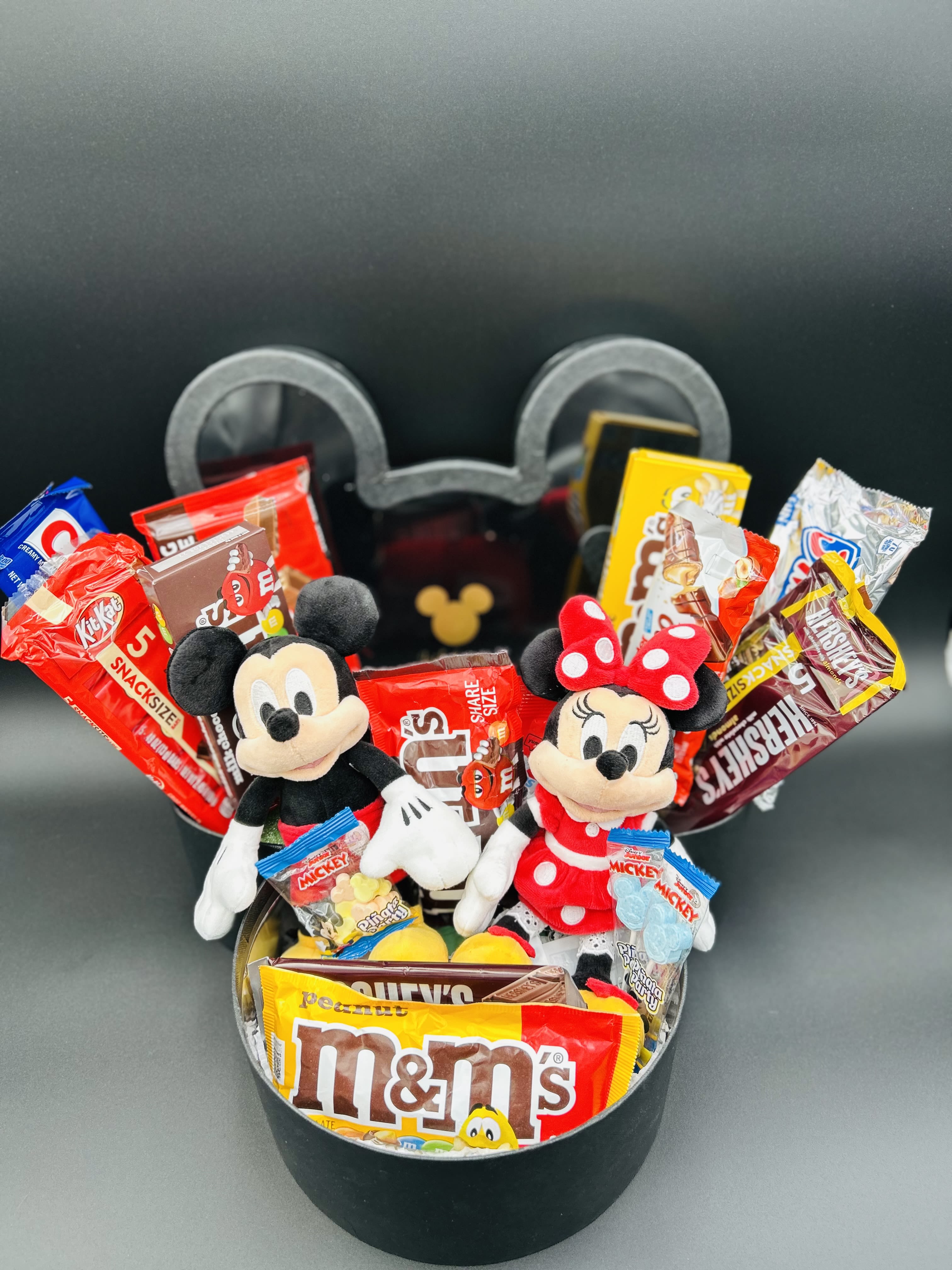 Mickey and Minnie plush toys in a black gift box with assorted candy