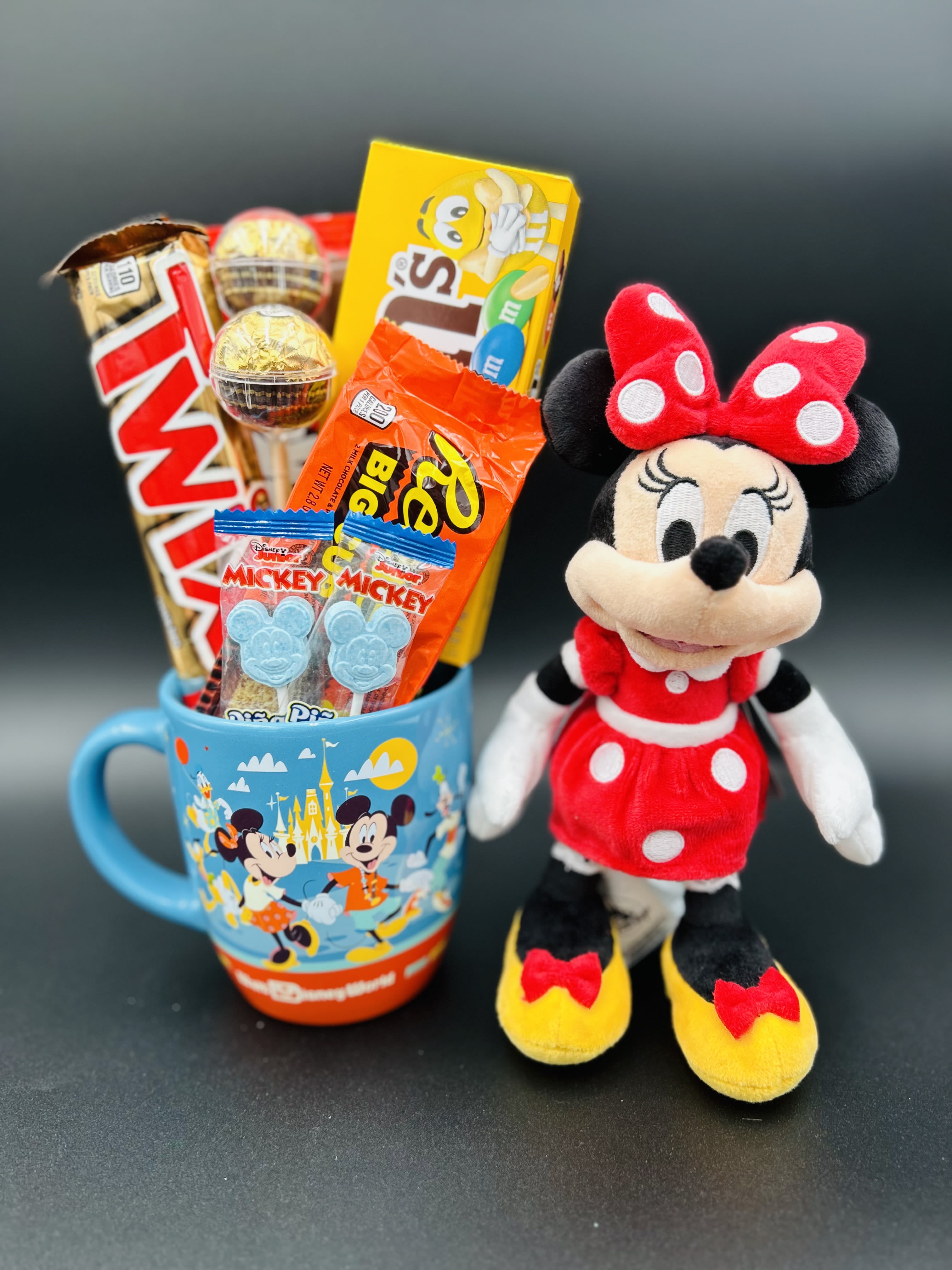 Minnie Mouse plush beside a mug filled with assorted candy