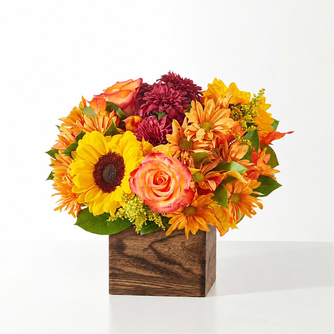 Mixed bouquet in a wooden cube vase with sunflowers and roses