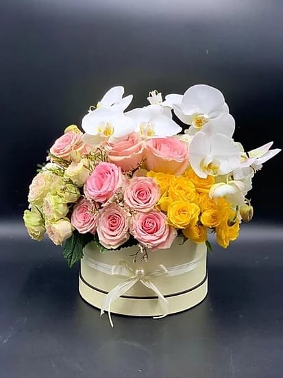 Pink and yellow roses with white orchids in a round box