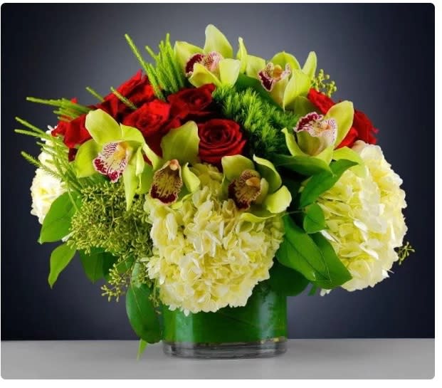 Red roses and pale green orchids in a glass vase