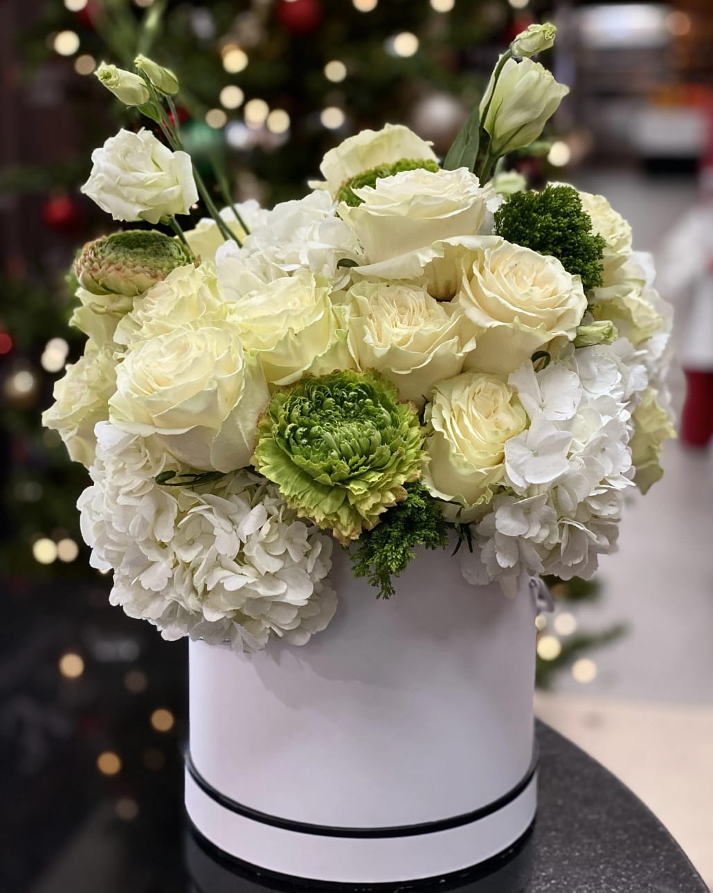 White roses and hydrangeas in a round white box