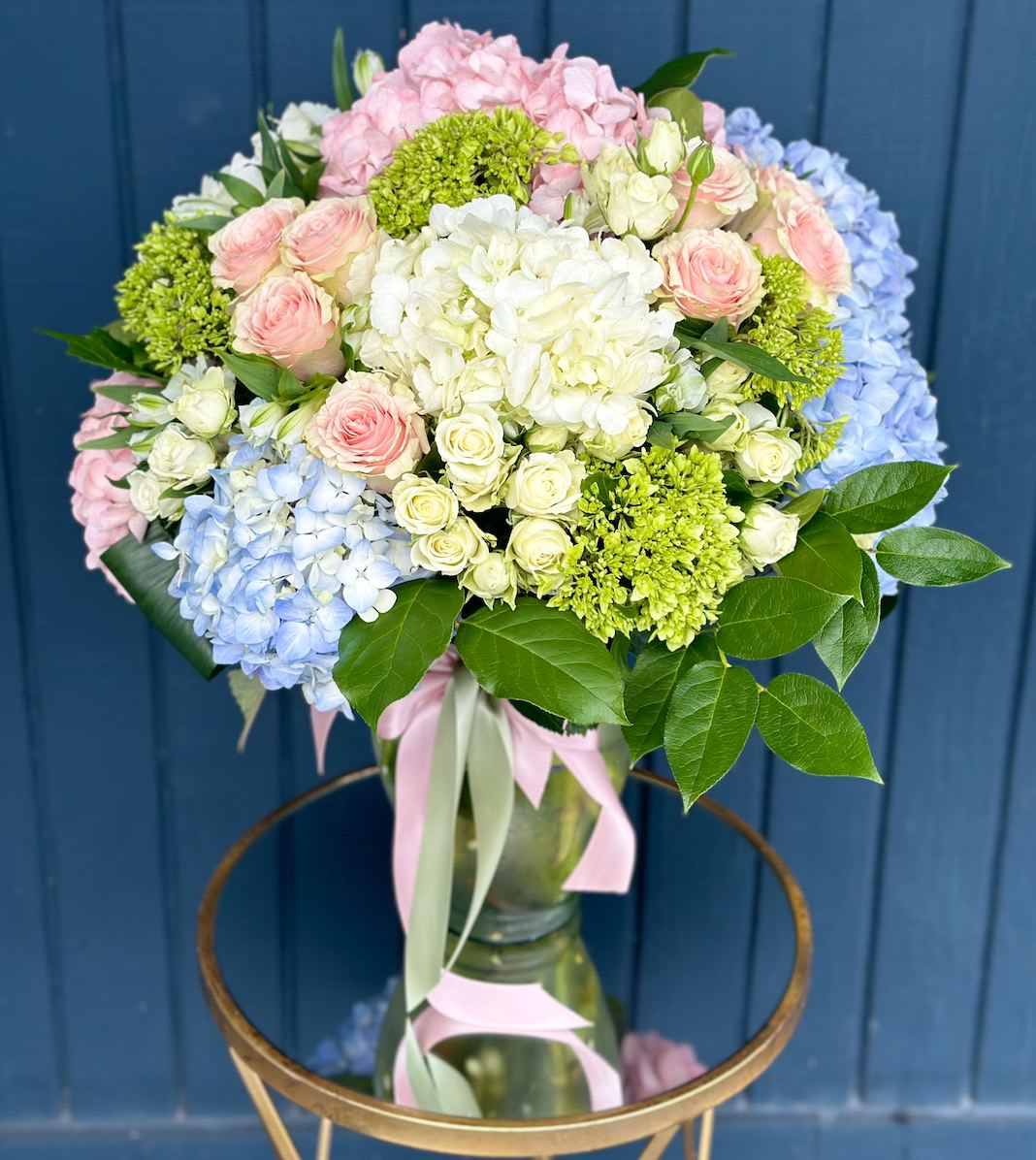 Pastel bouquet of hydrangeas and roses in a glass vase