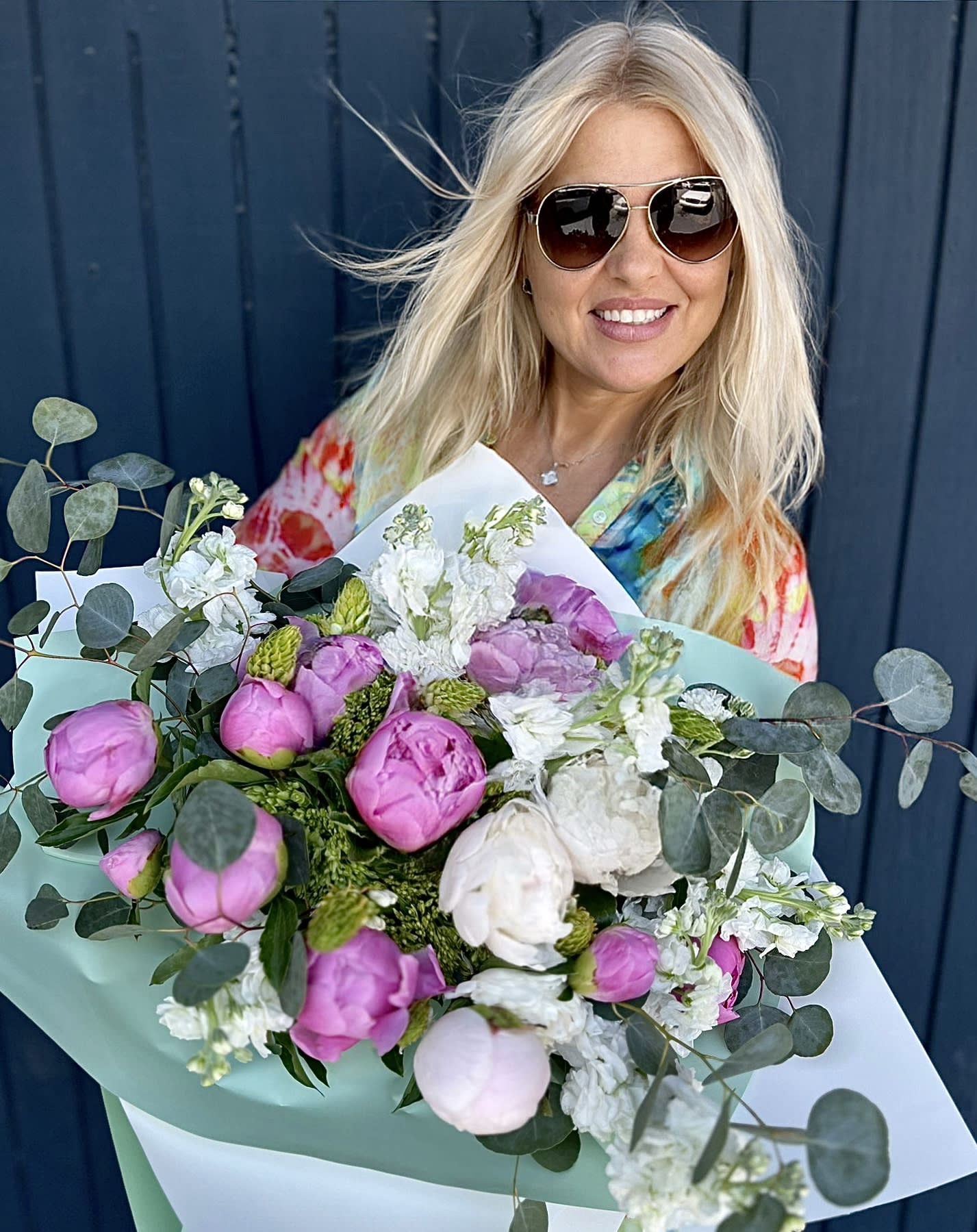 Bouquet of pink and white peonies with eucalyptus in pastel wrapping