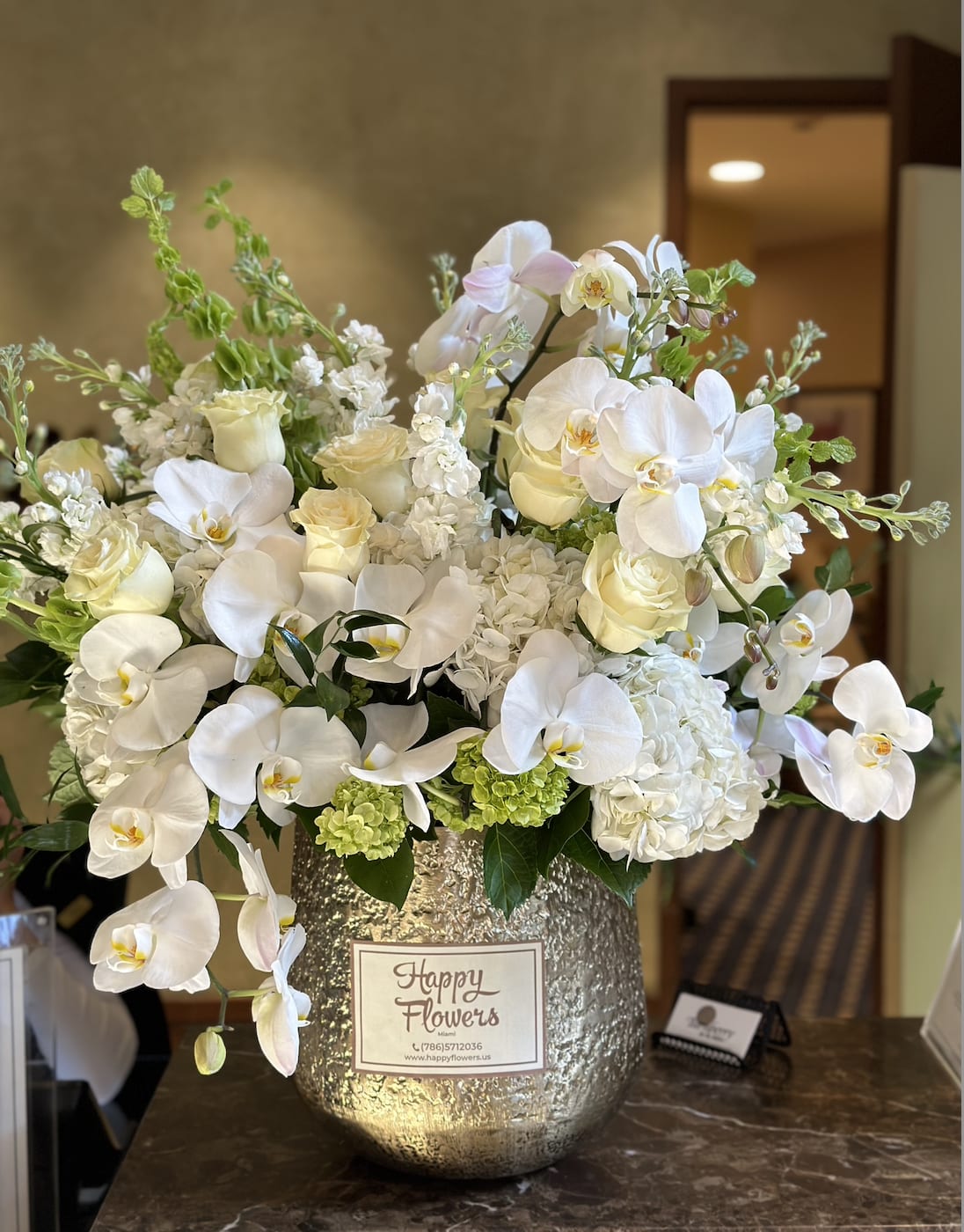 White Marveles - Large size of arrangement in a gold vase with orchids.A bouquet that will captivate many  ▪️ Delivery to their door Each bouquet is unique and is prepared by an expert florist and our customer service team is at your service to ensure the best experience possible.  ▪️Bouquets you can enjoy for longer Some flowers arrive a little closed to ensure extra freshness and protection during shipping. Enjoy the magic of seeing them fully bloom.