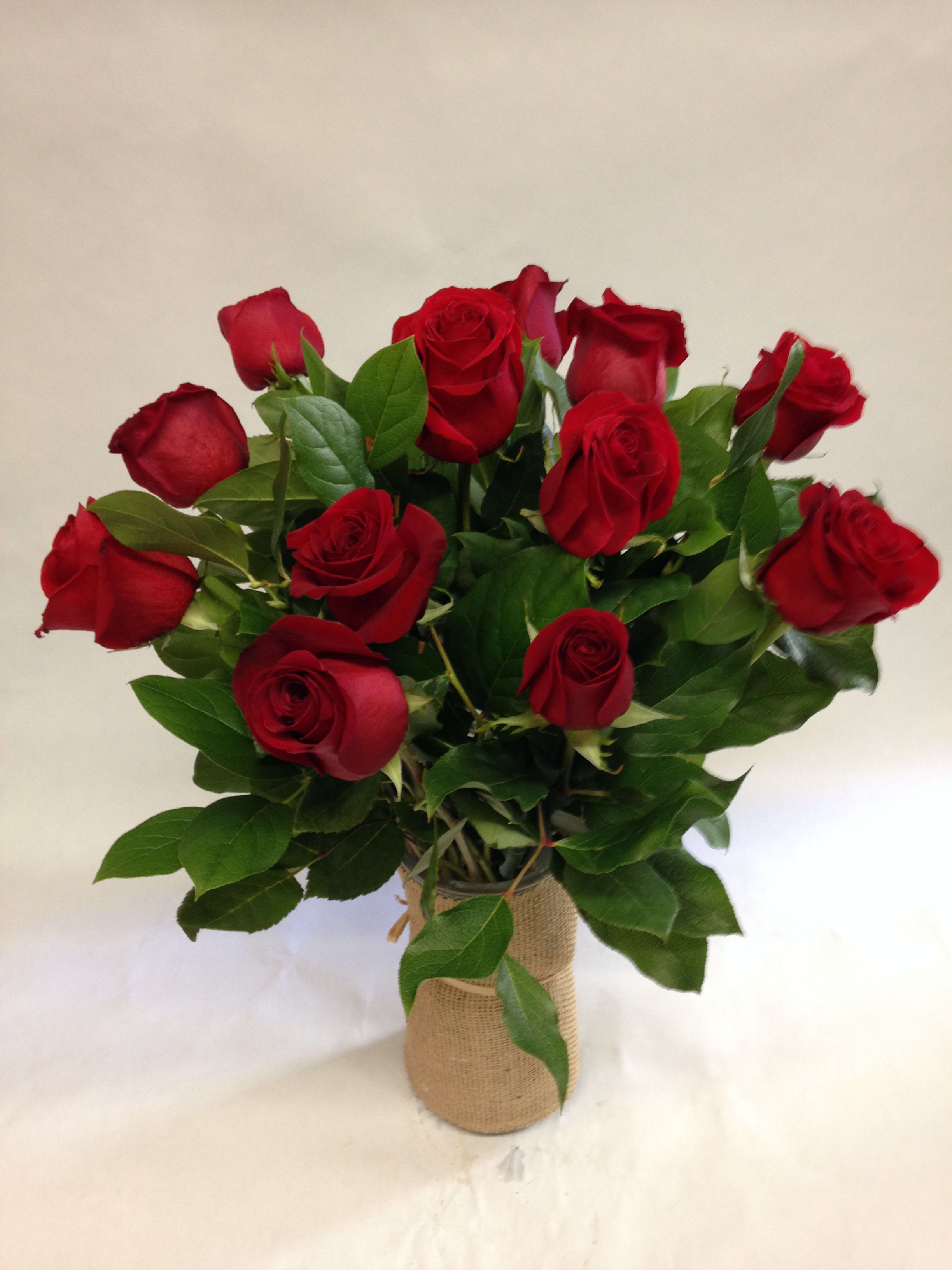 Bouquet of red roses in a burlap-wrapped vase