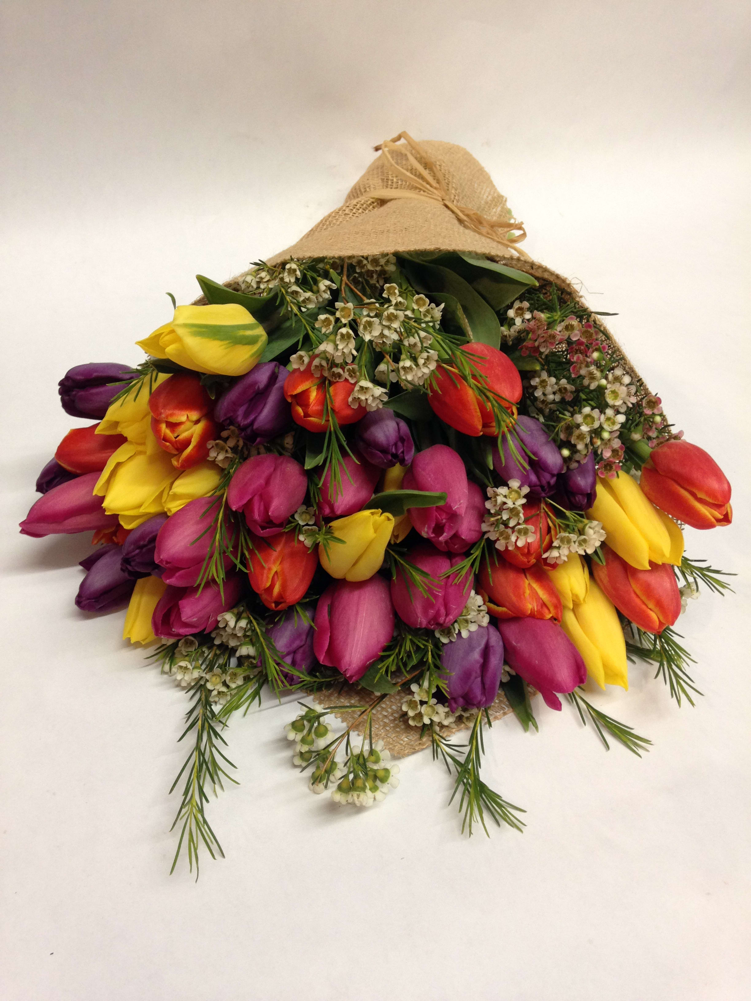 Bouquet of multicolored tulips wrapped in burlap