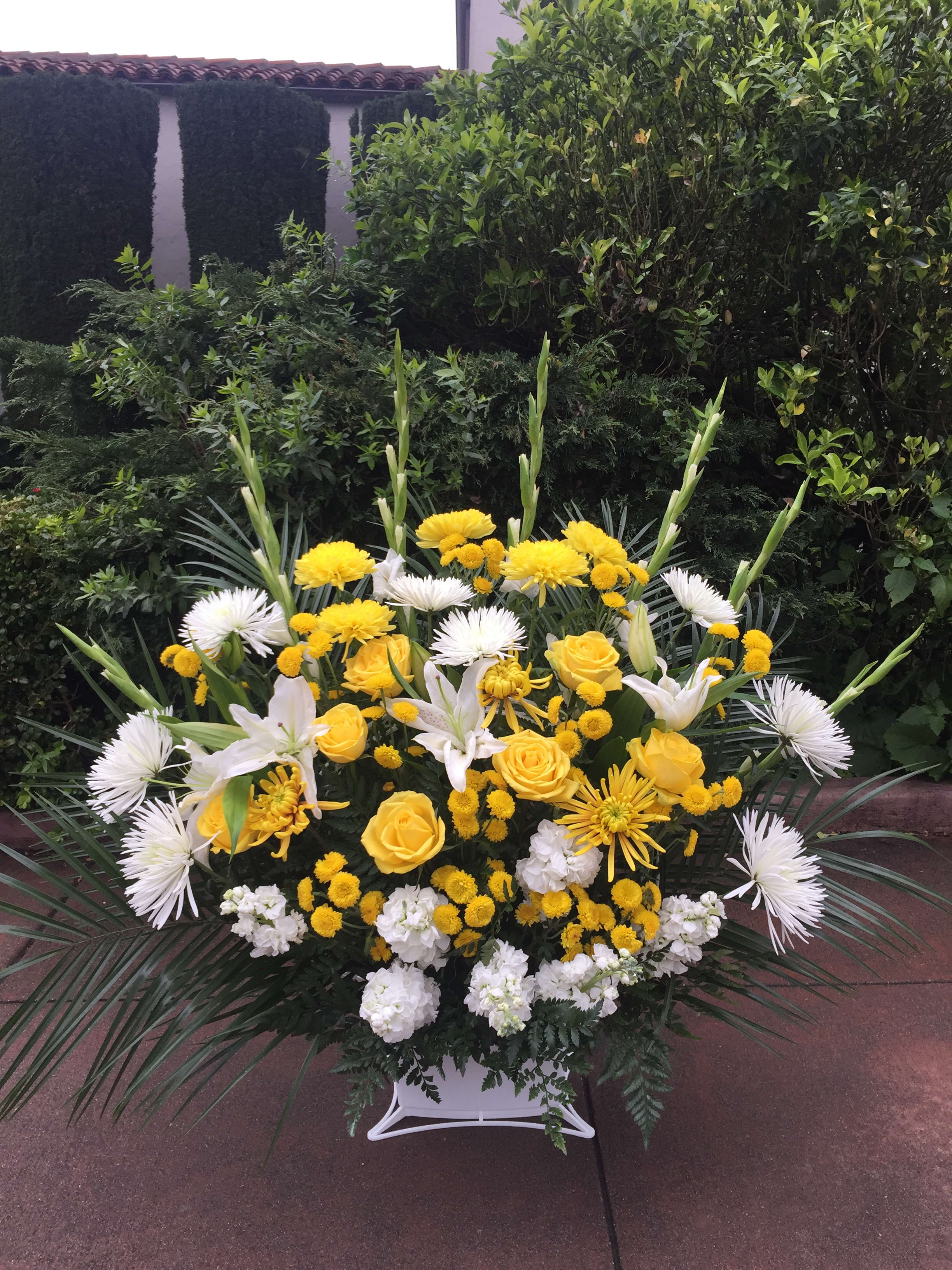 Yellow and white floral spray in a white container