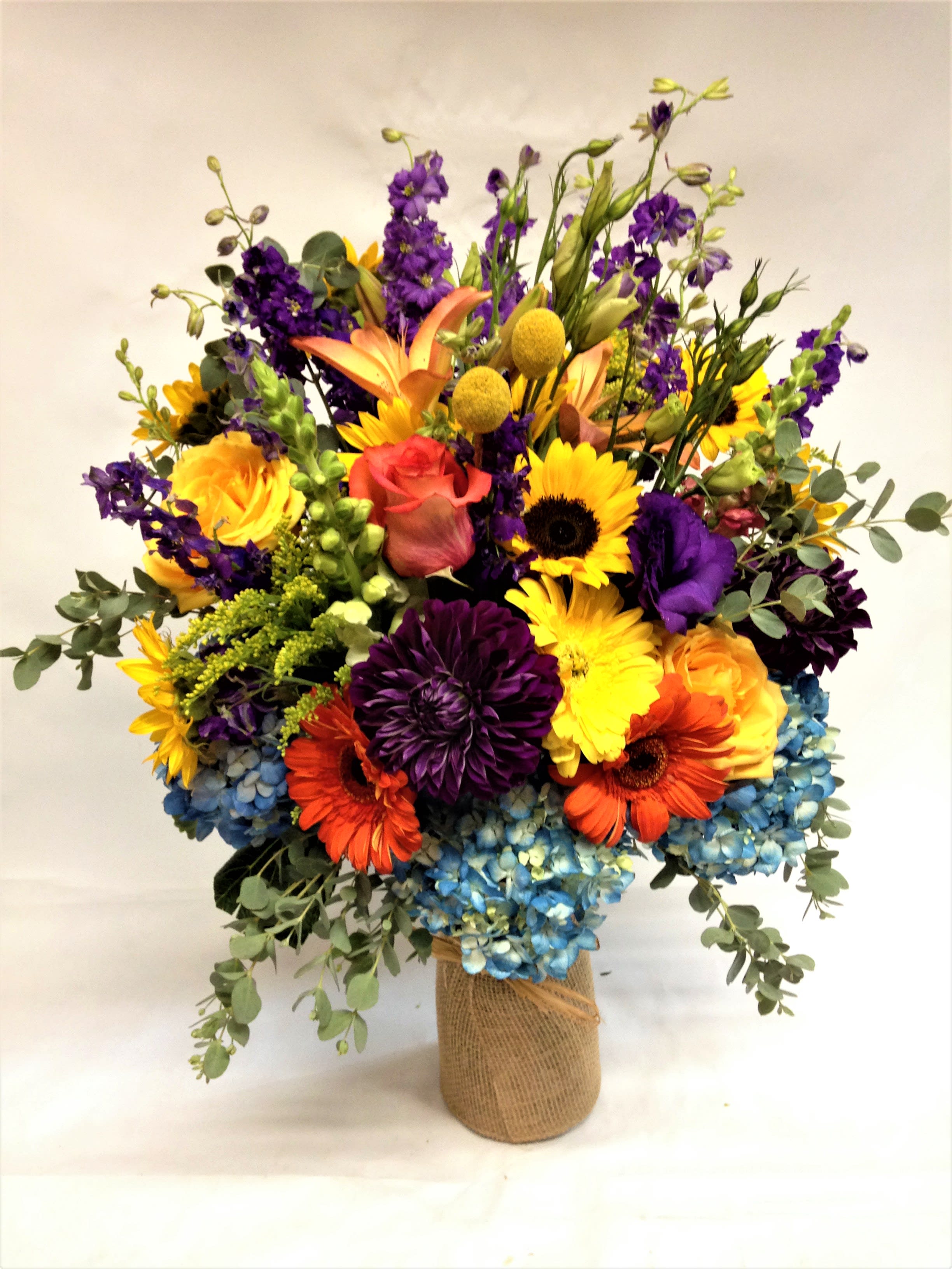 Colorful mixed bouquet in a burlap-wrapped vase