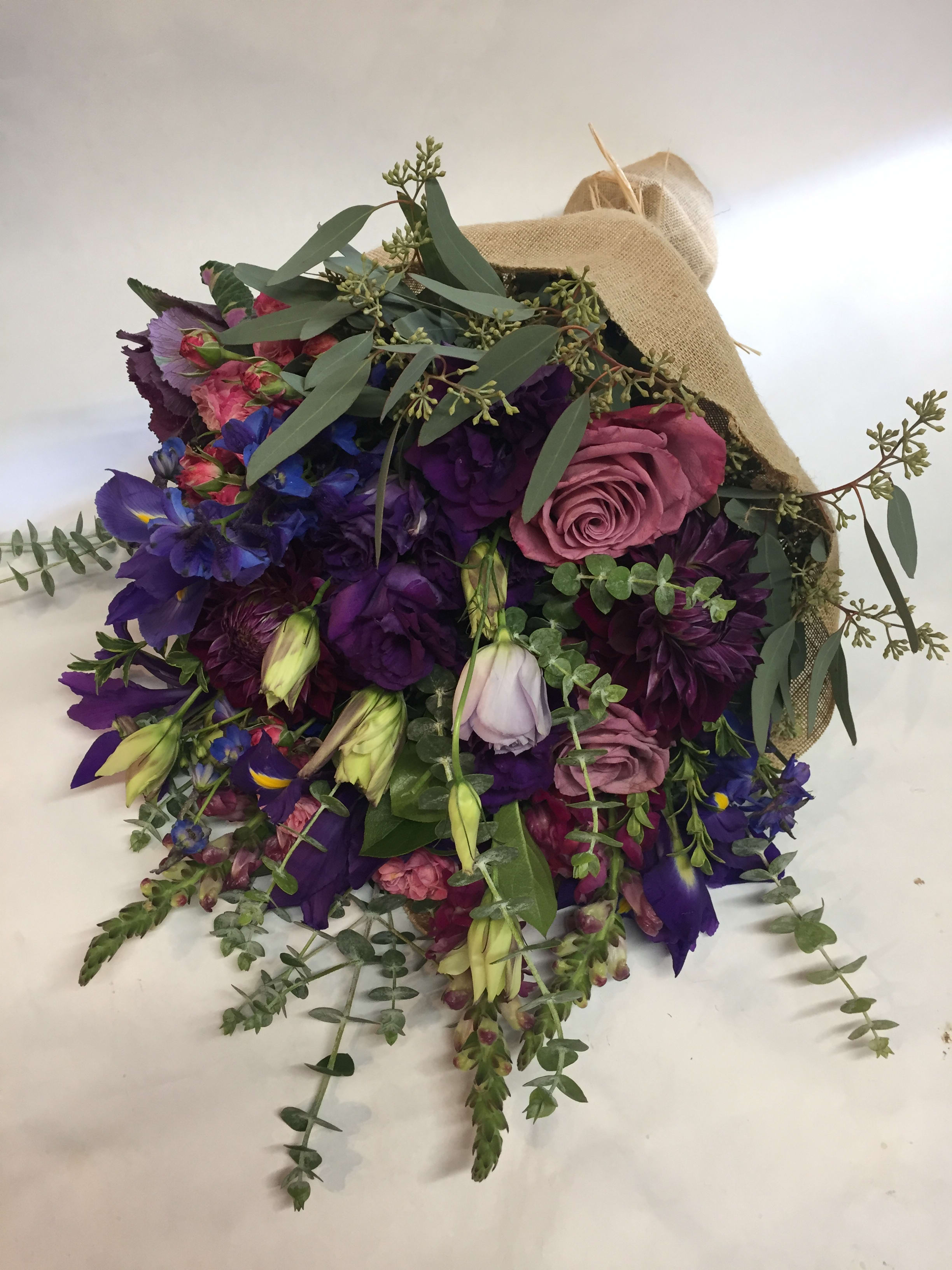 Bouquet of purple and pink flowers wrapped in burlap
