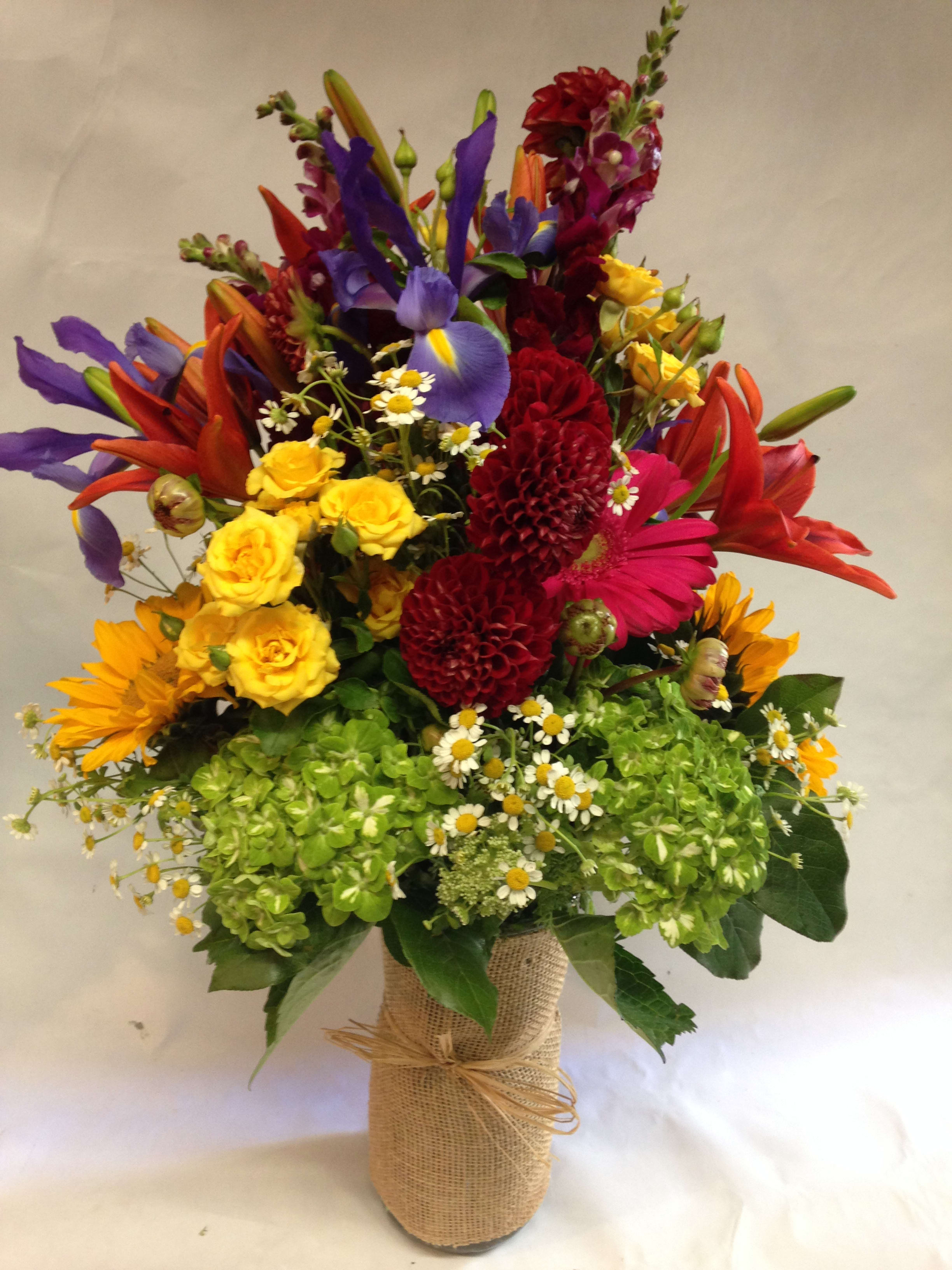 Colorful mixed bouquet in a burlap-wrapped vase
