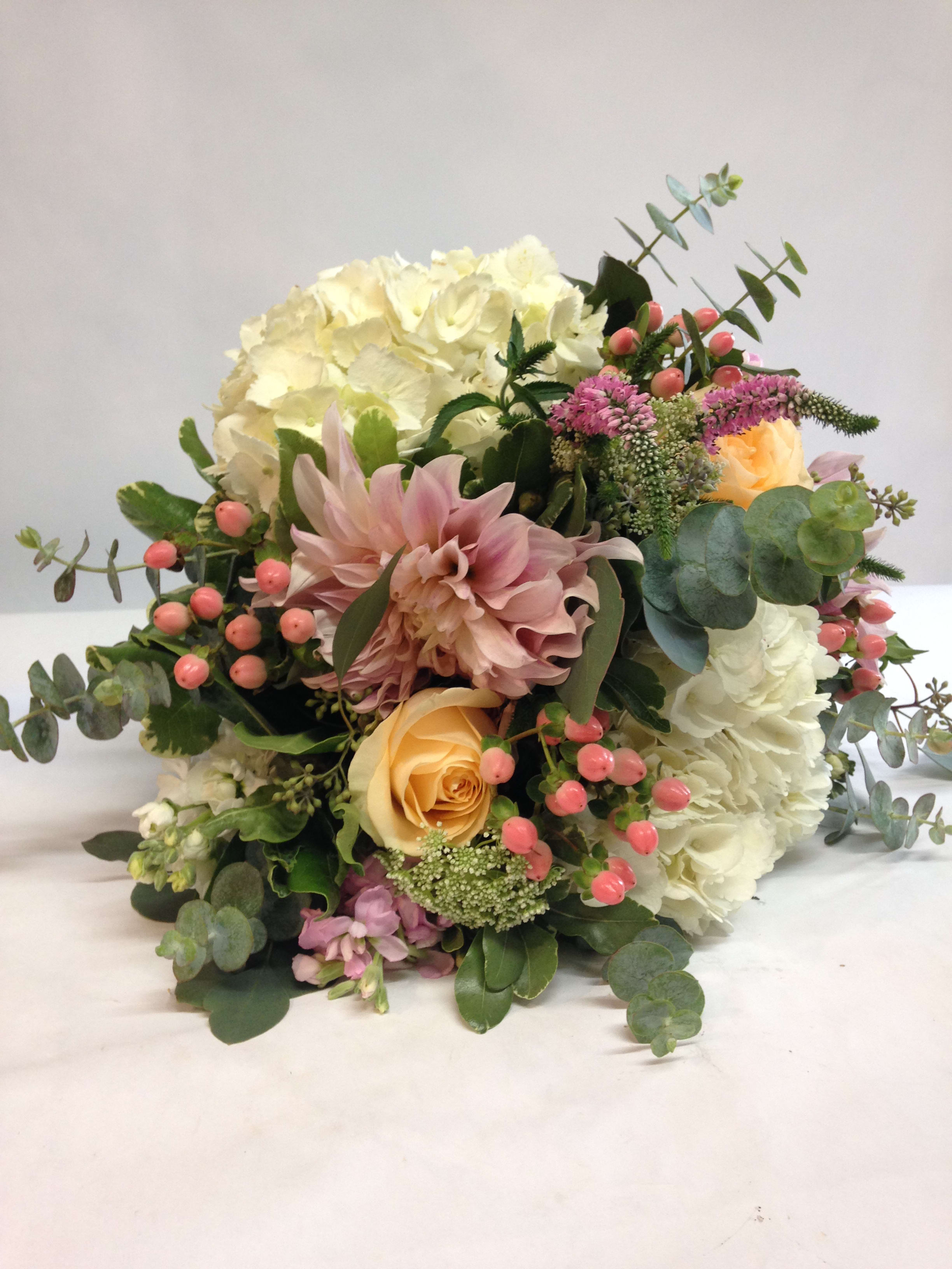 Bouquet of white and blush flowers with pink berries and eucalyptus