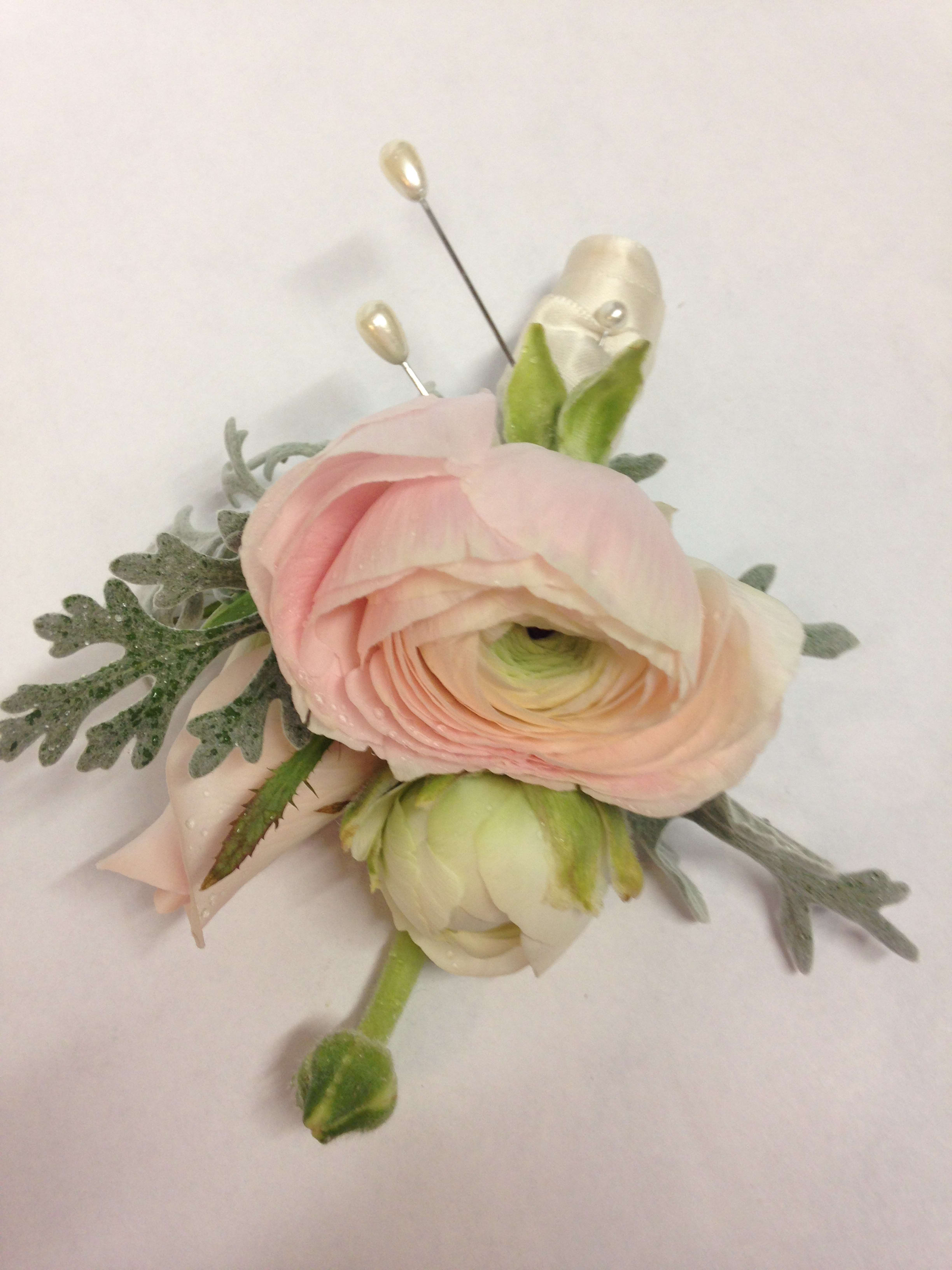 Pink ranunculus boutonniere with pale ribbon and pearl pins