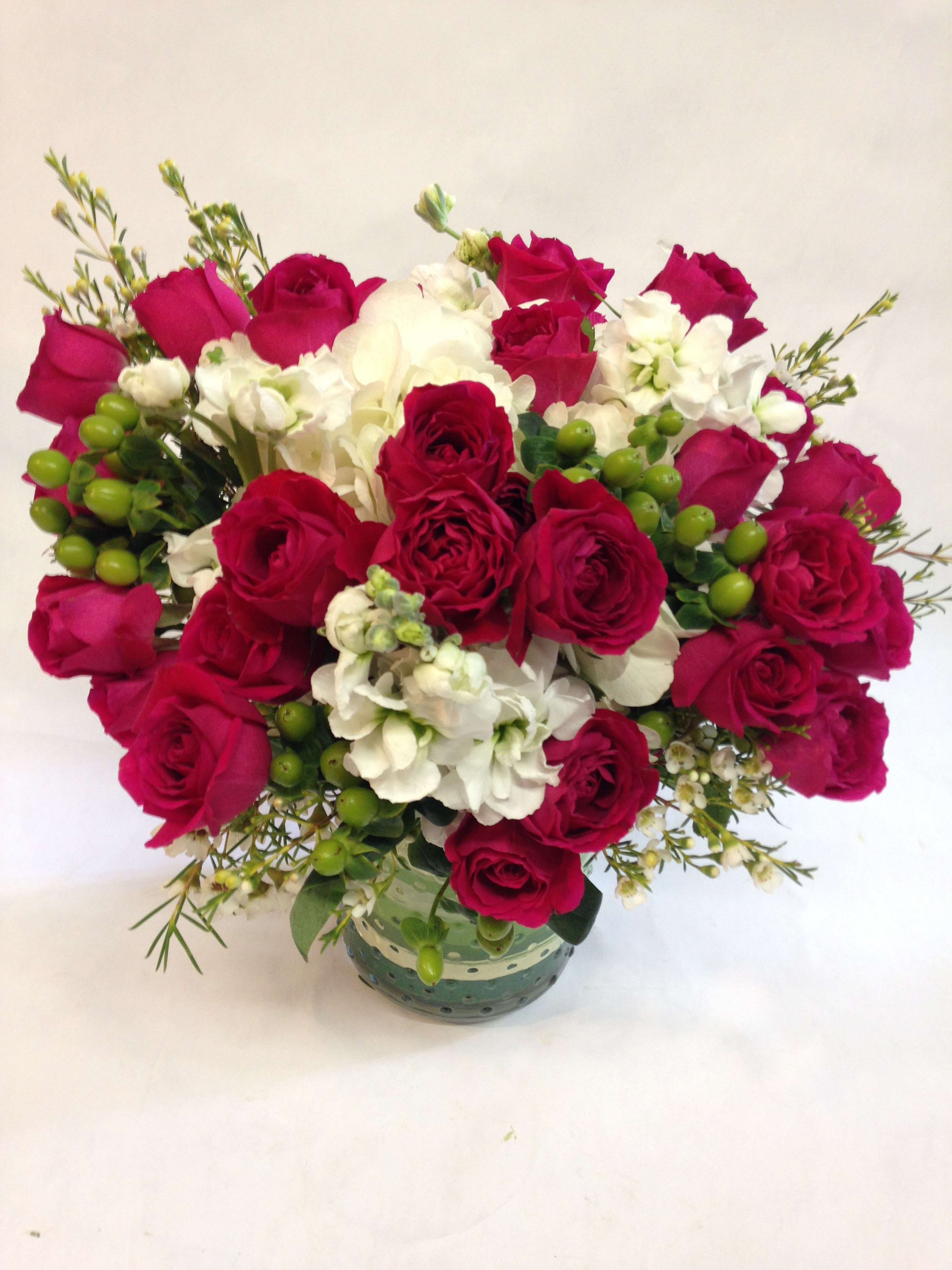 Bouquet of red roses and white flowers in a glass vase