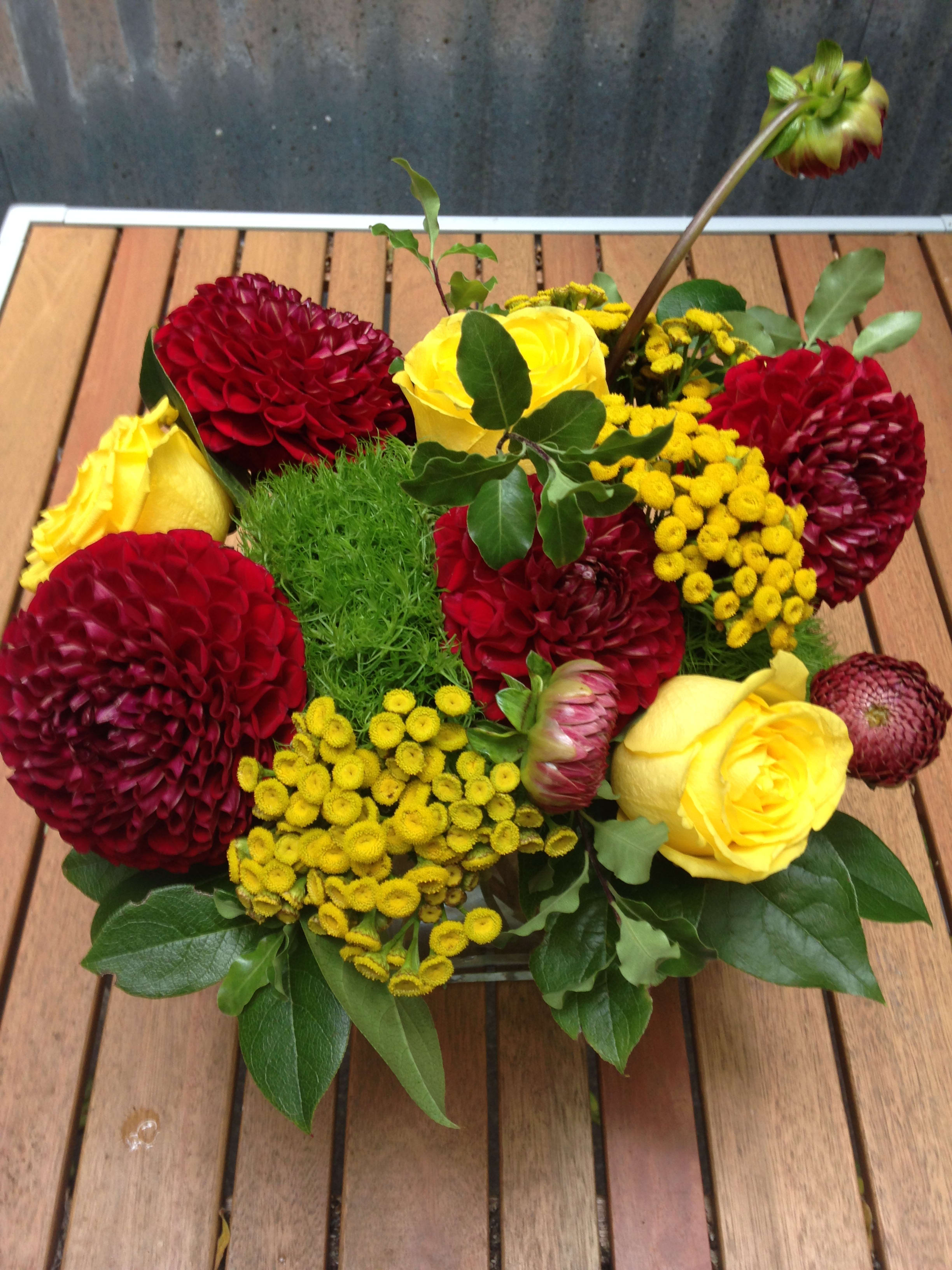 Low bouquet of red and yellow flowers in a container