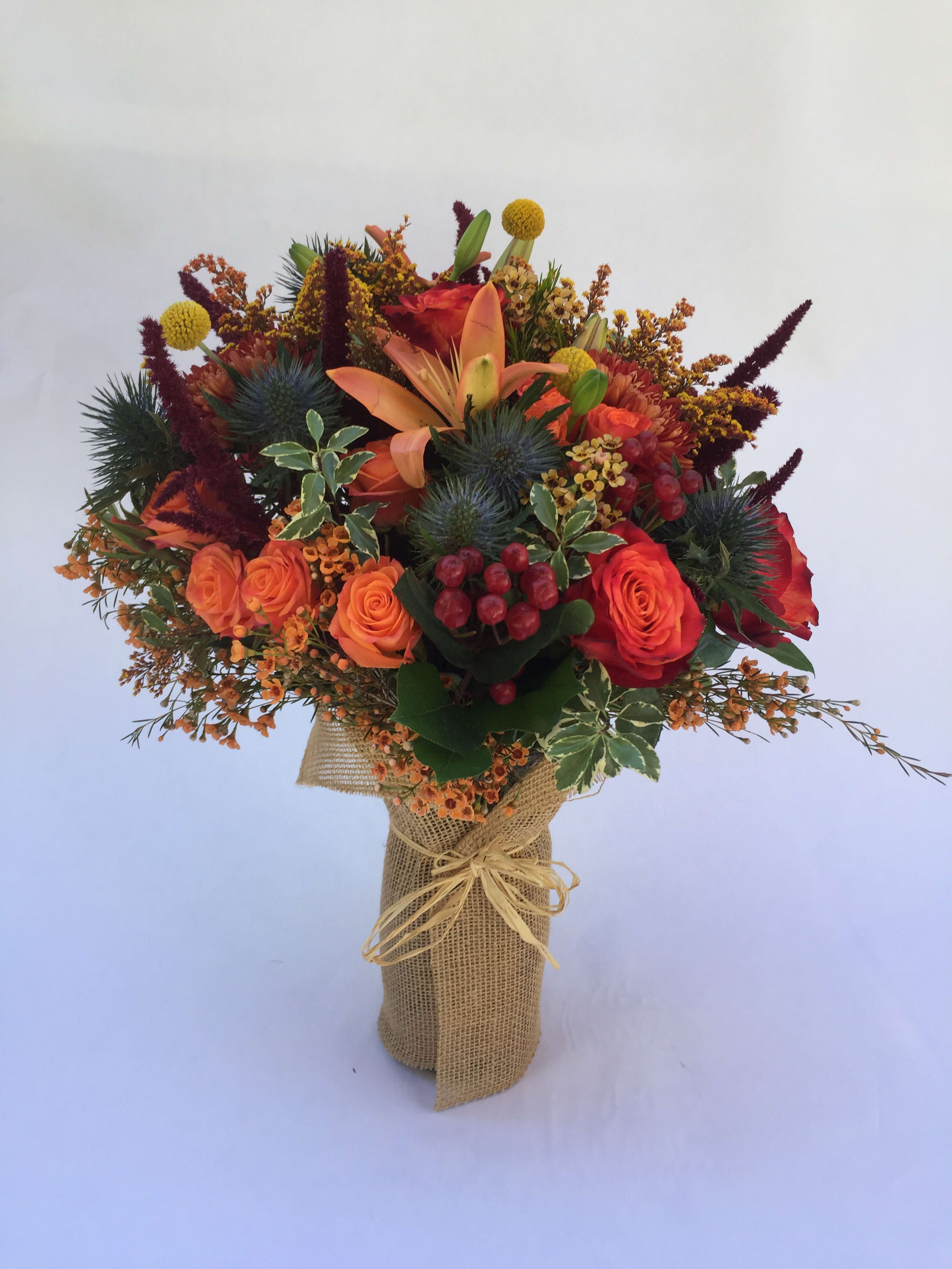 Bouquet of orange and red flowers wrapped in burlap