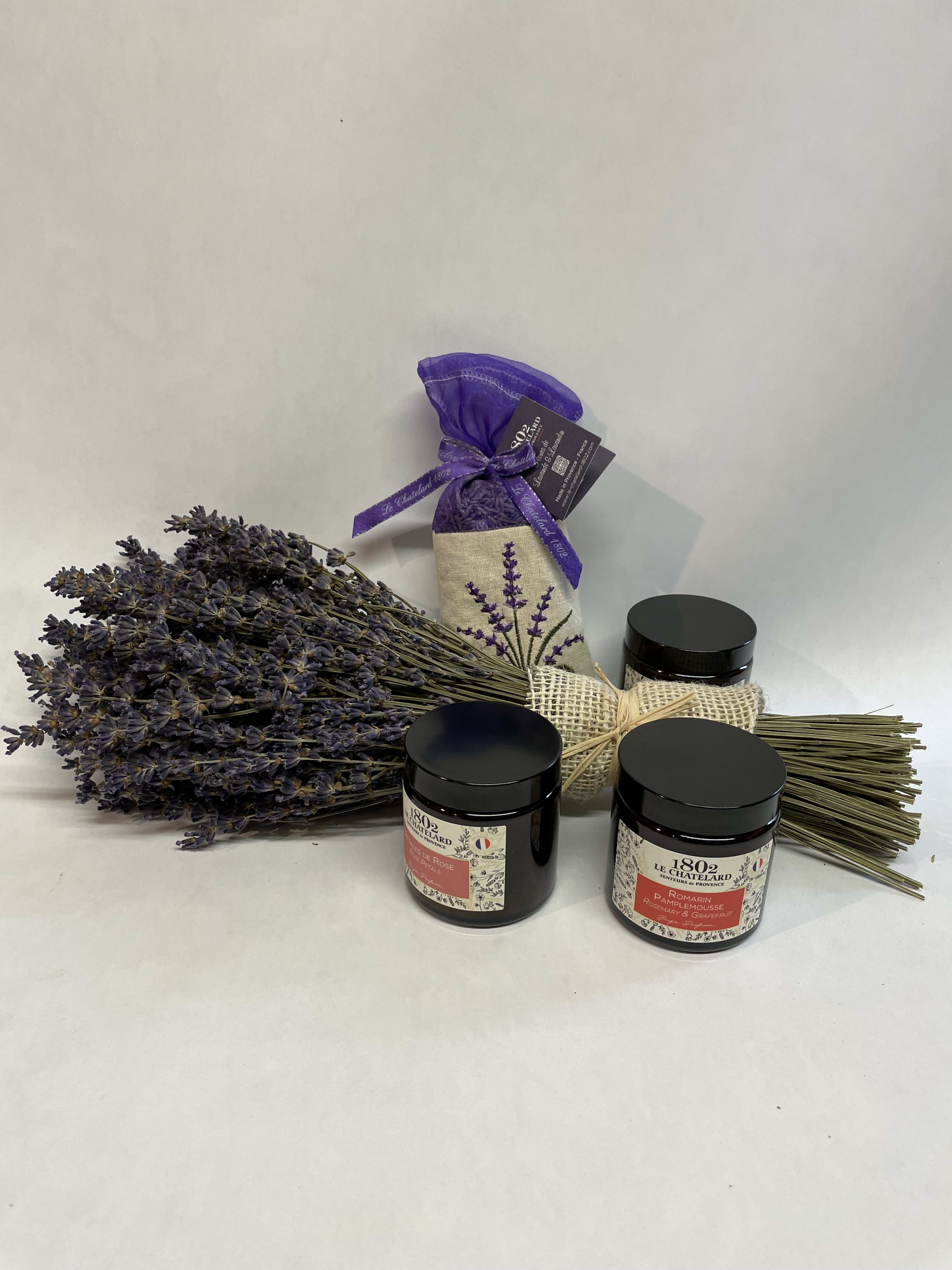 Bundle of dried lavender with three black-lidded jars and a purple sachet