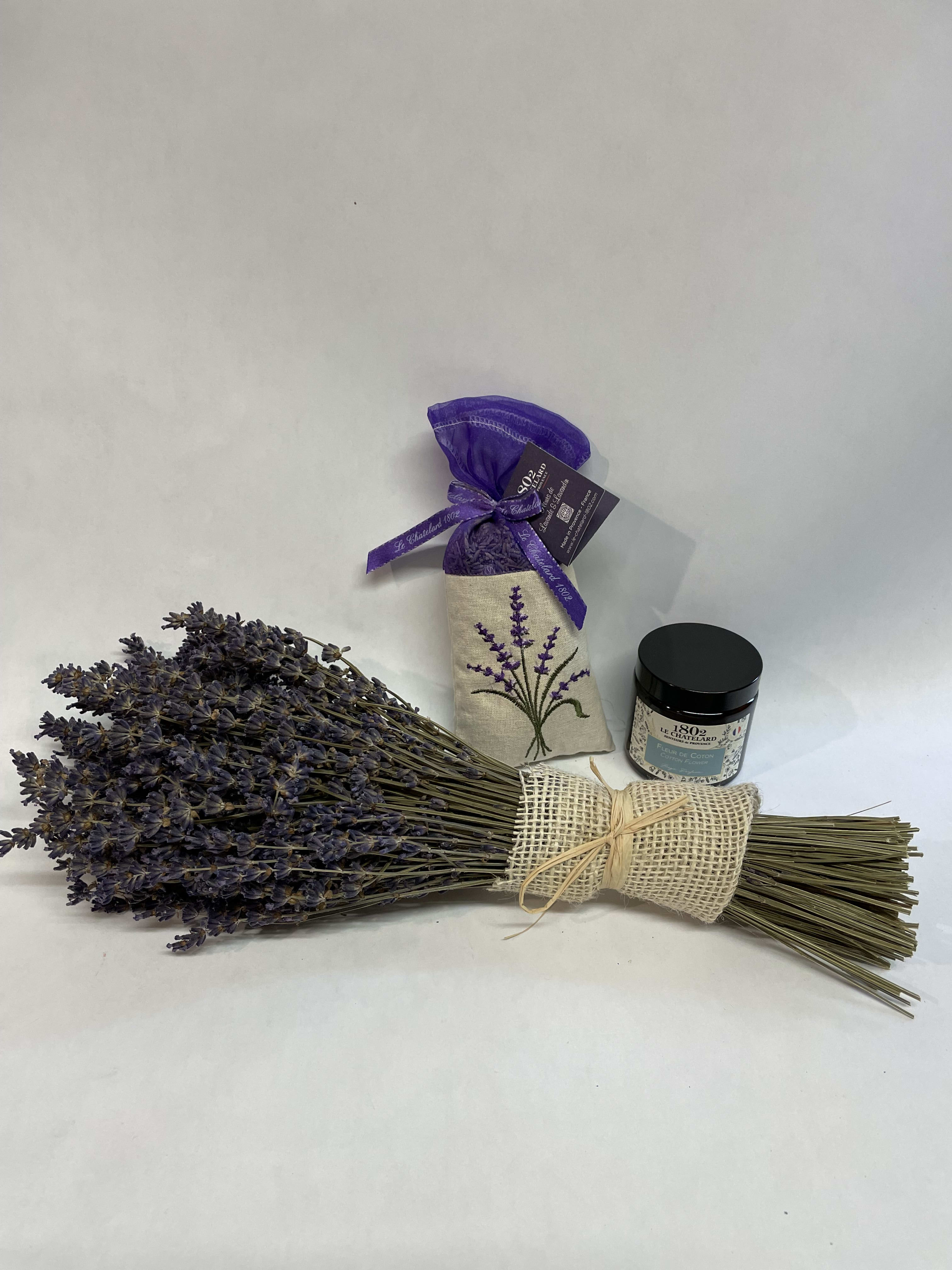 Bundle of dried lavender with a small candle jar and sachet