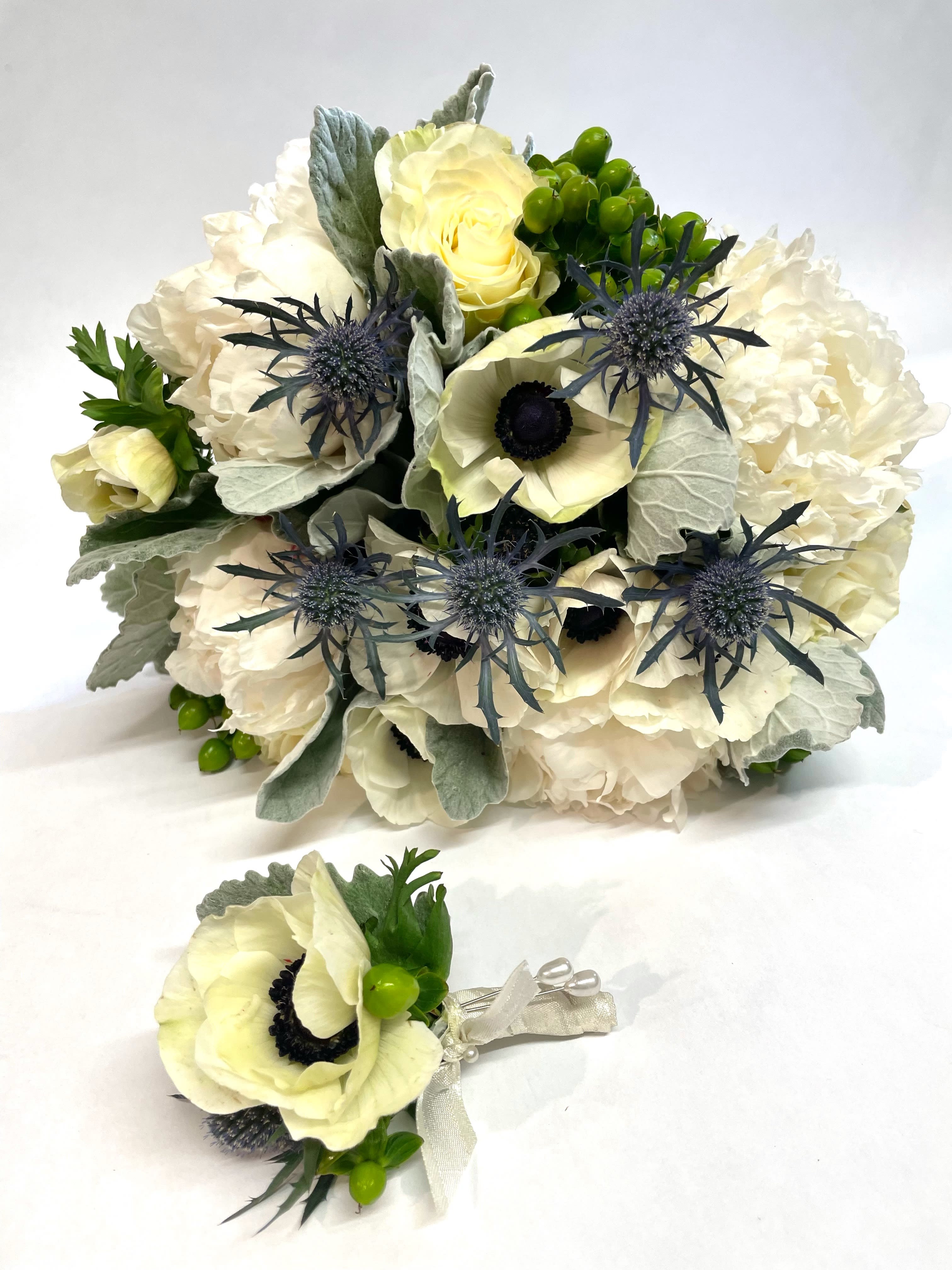 Cream bouquet with blue thistle and a matching boutonniere